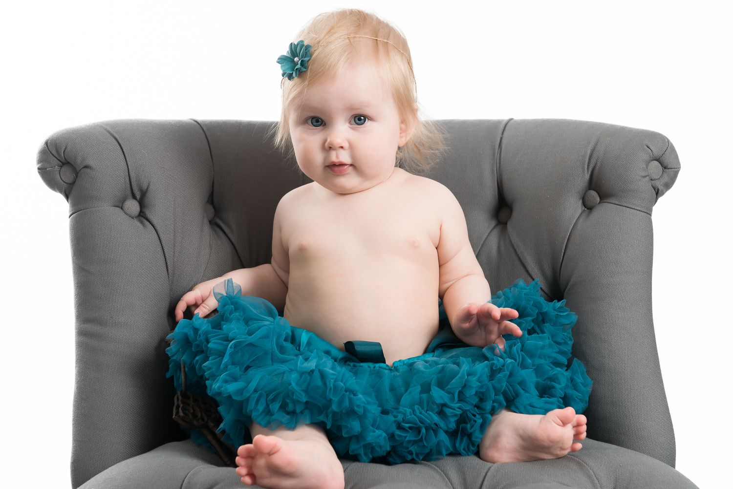 Baby portrait session on gray chair with teal tutu.