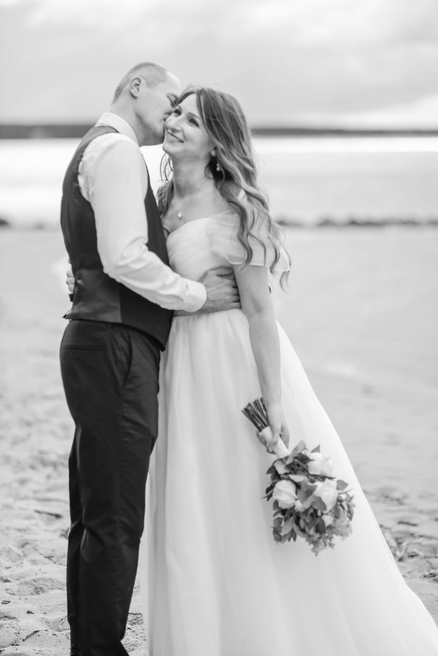 Tender wedding photography showing couple's romantic moments on beach.