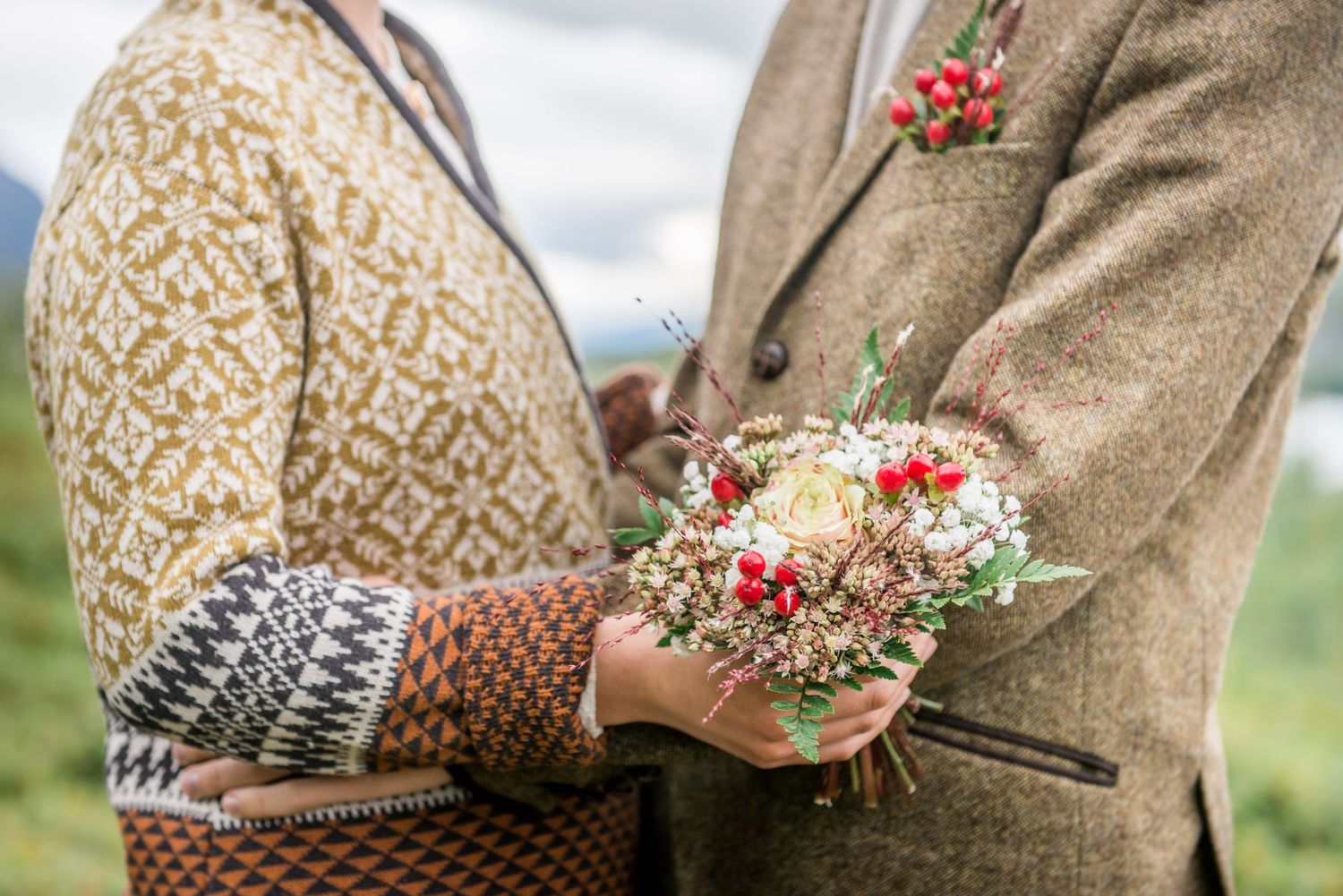 Close-up of tweed and floral wedding details against rustic backdrop.