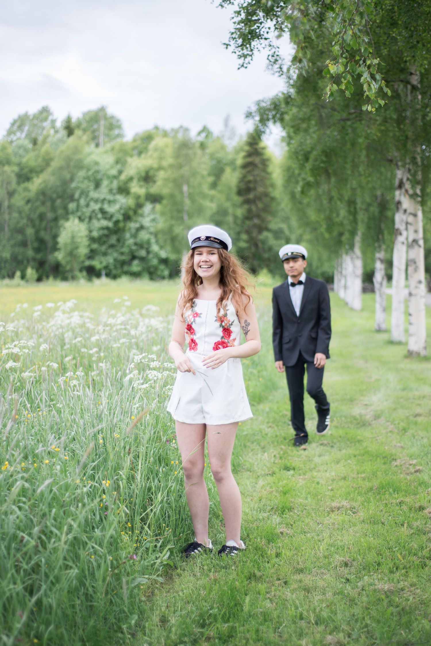 Couple enjoying a romantic photoshoot among birch trees and wildflowers.