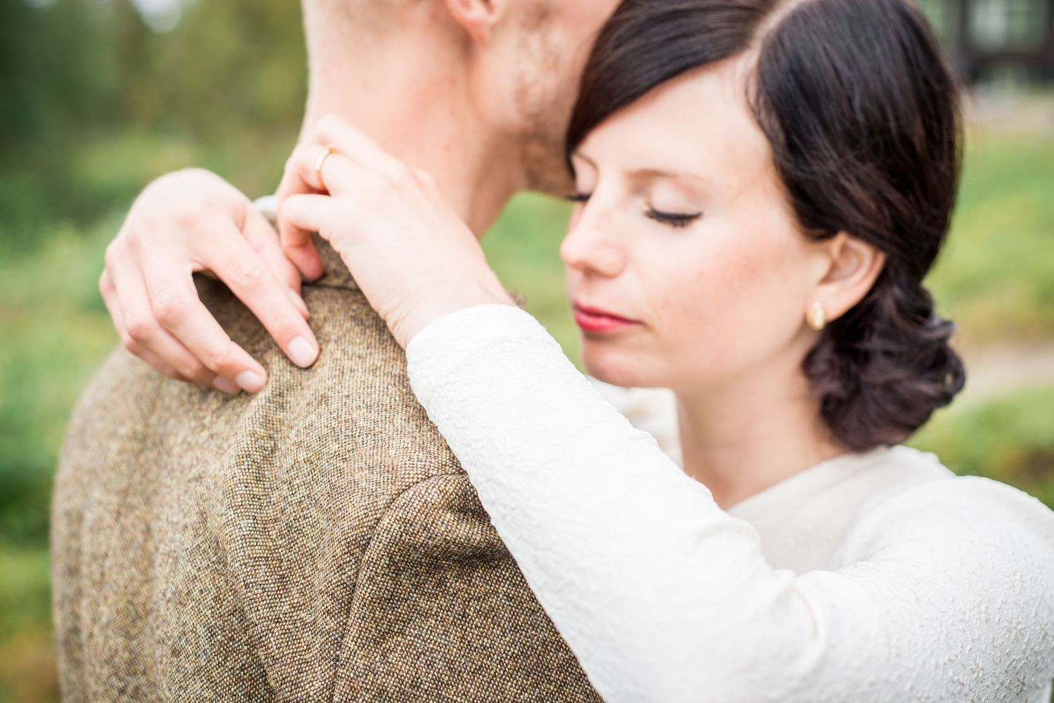 Artistic close-up of wedding couple in intimate pose with natural lighting.