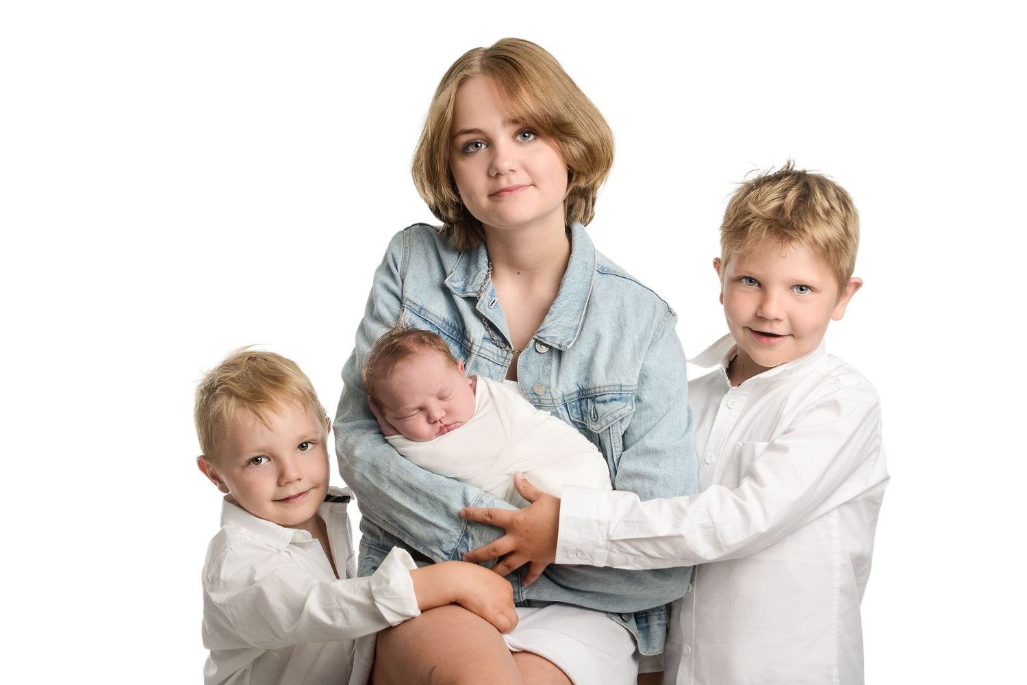 Family portrait with casual denim and white clothing against white backdrop.
