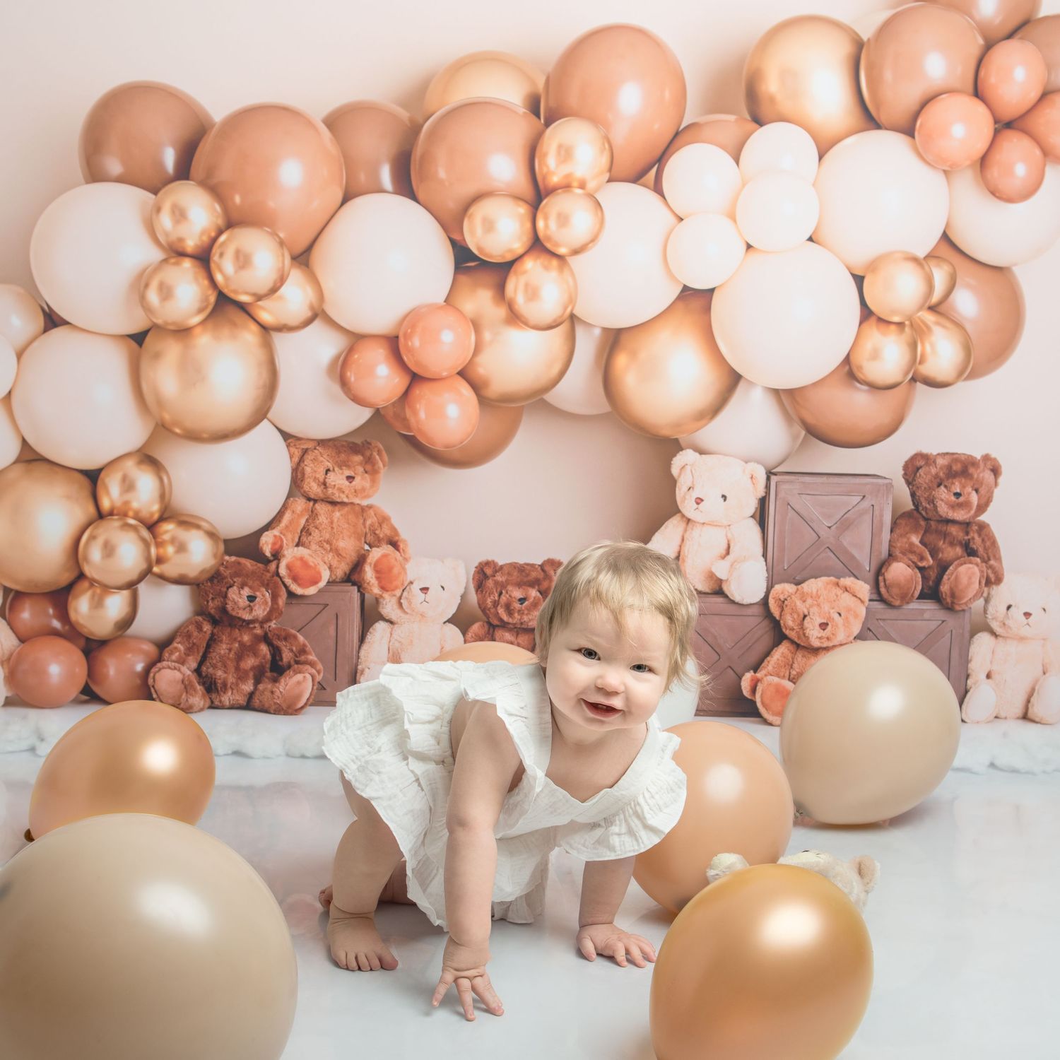 A festive setup with rose gold balloons and teddy bears creates a warm party atmosphere.