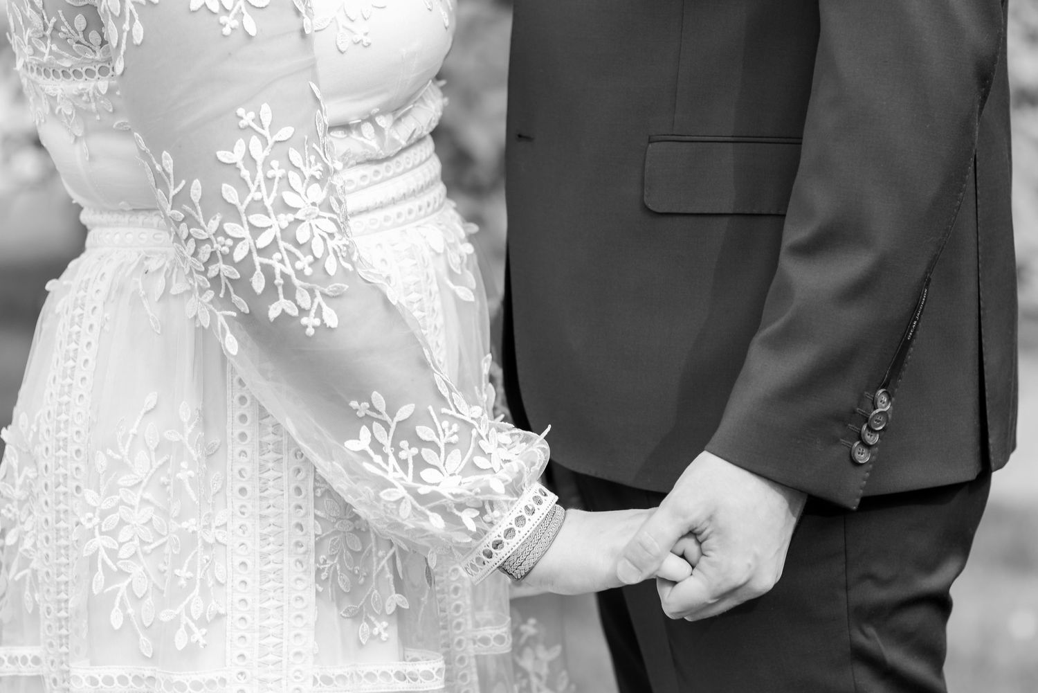 Close-up detail of intricate lace wedding dress with delicate button details.