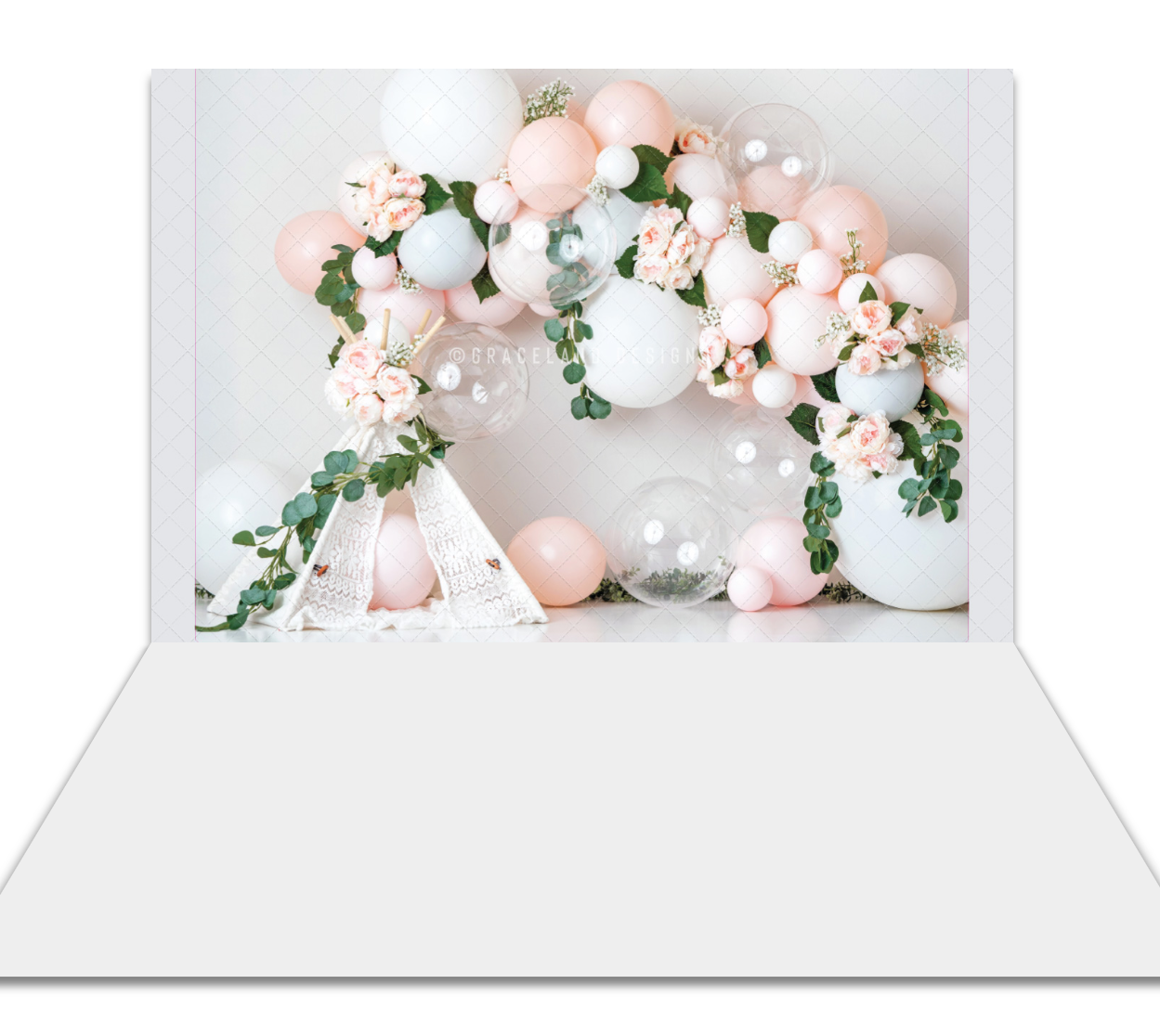 Elegant balloon arch with pink, white flowers and greenery on white backdrop for party photography.