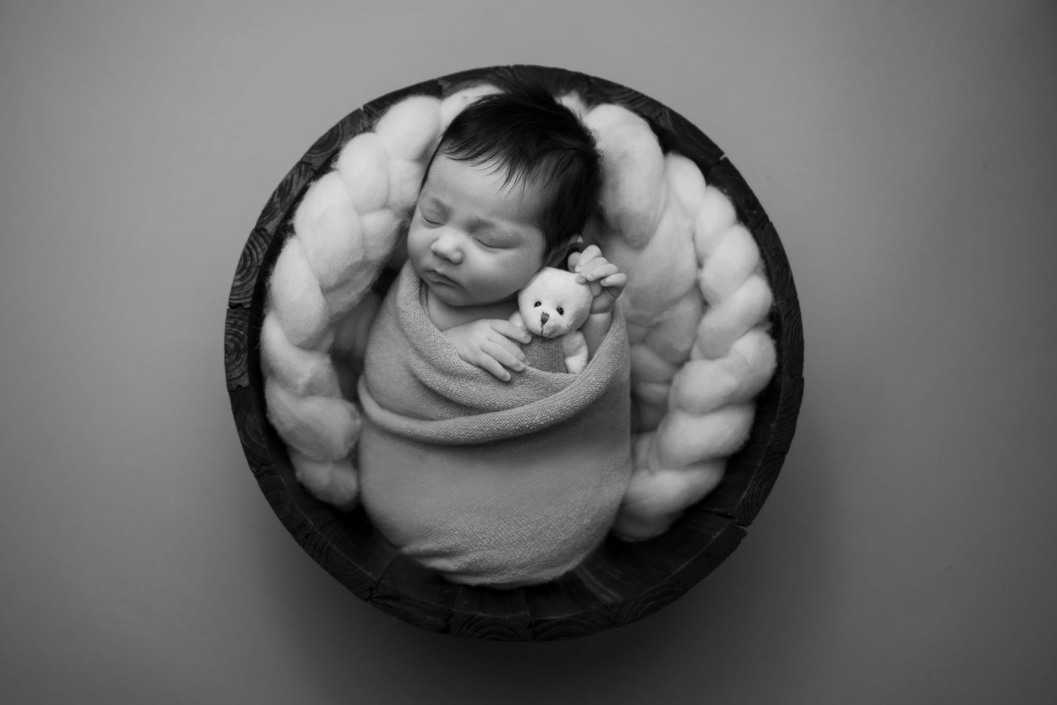 Series of peaceful newborn portraits in circular frames with gentle grayscale tones.