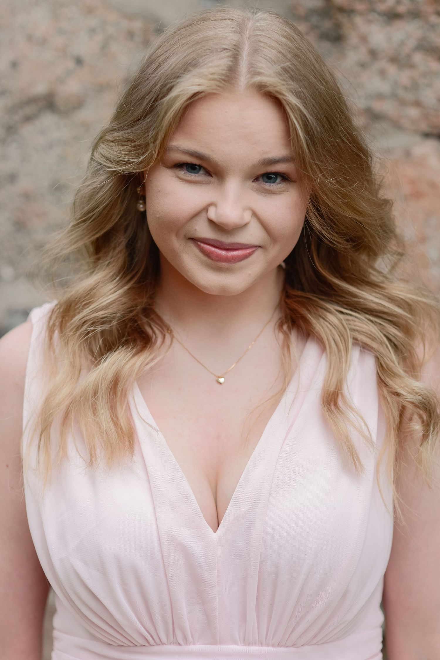 Close-up portrait with soft lighting and pink clothing.