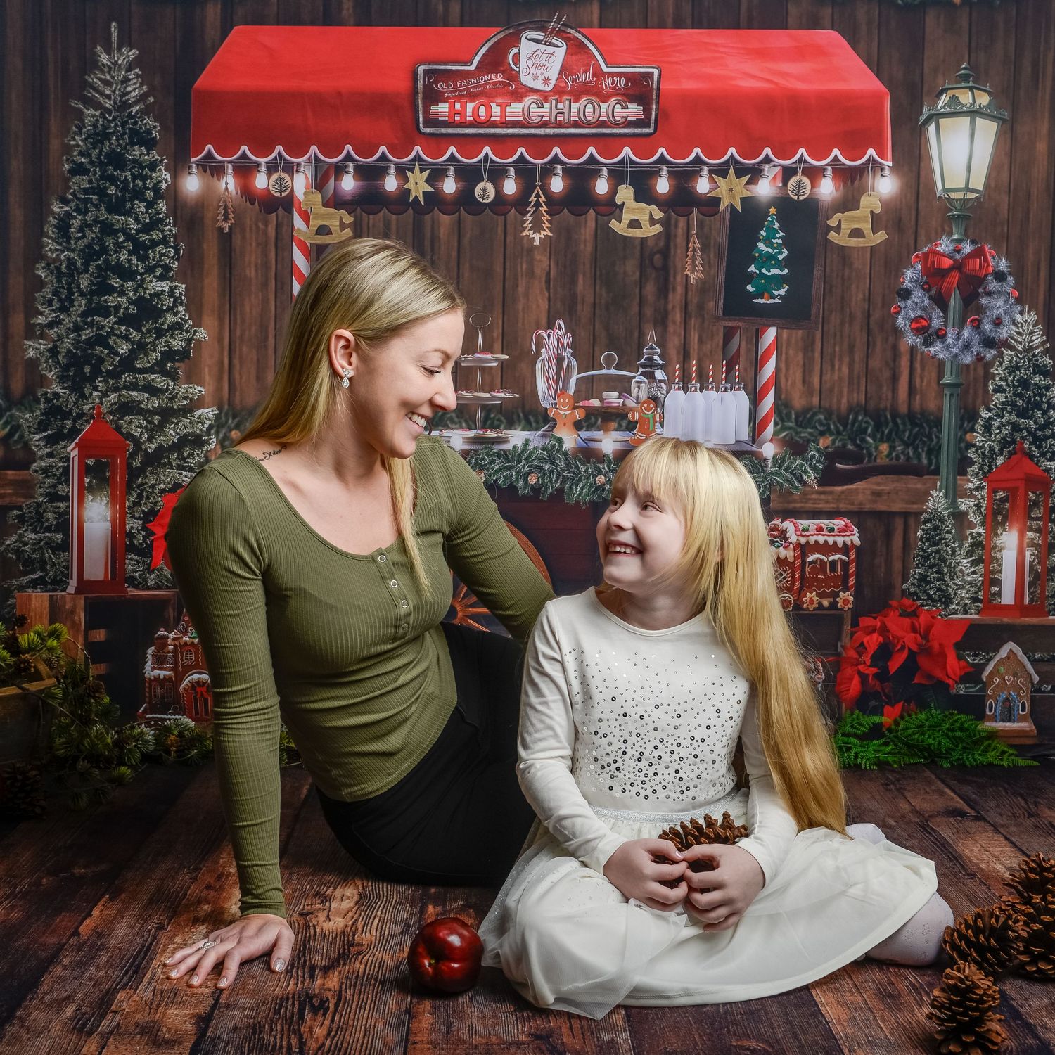 Christmas photo scene with red storefront backdrop and festive holiday decorations.