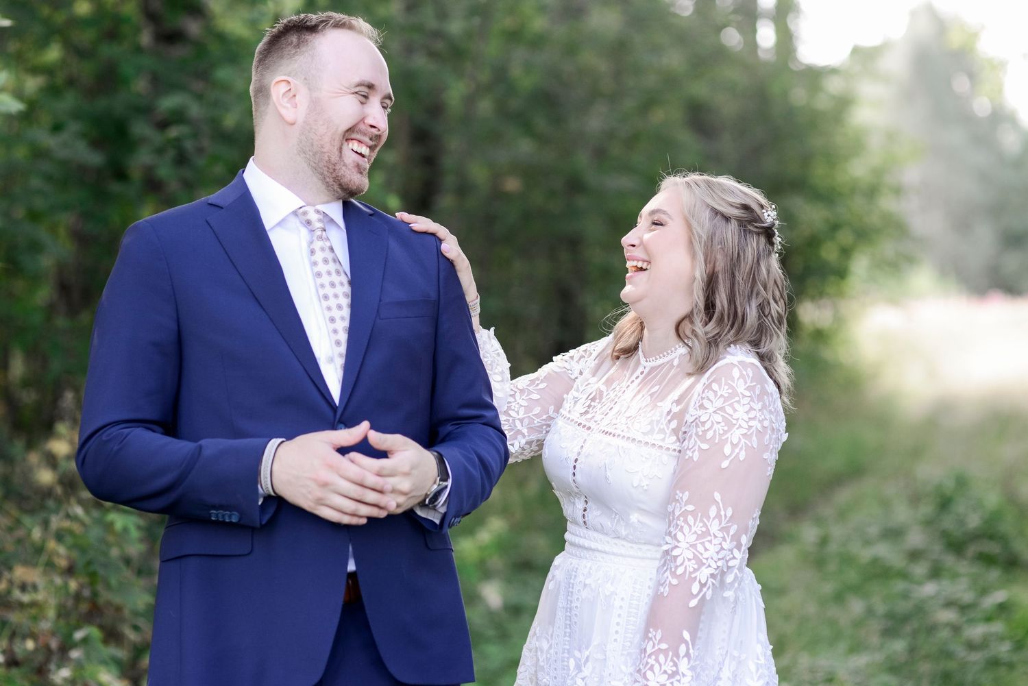 Candid engagement photography capturing genuine smiles and laughter in nature.