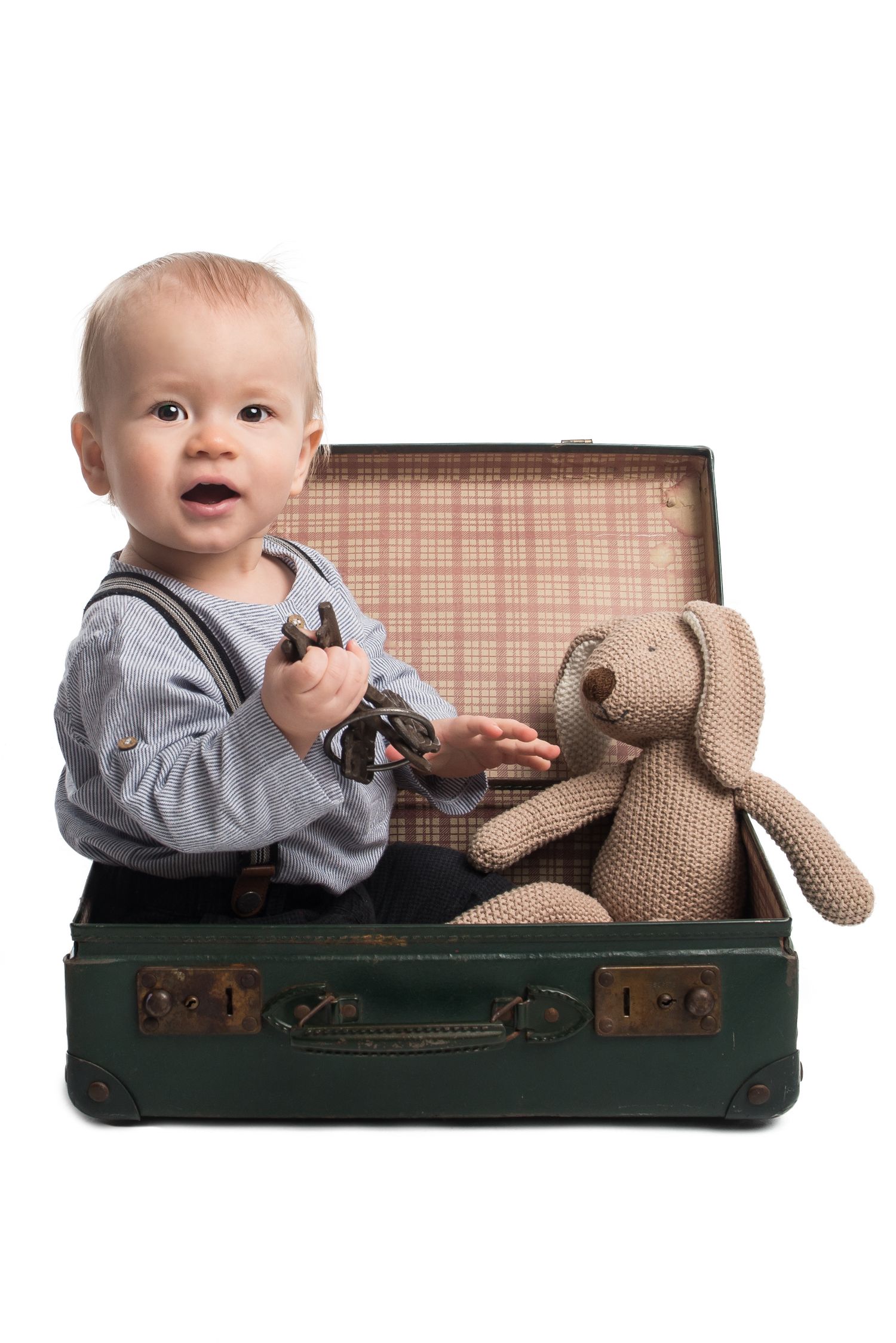 A series of three photos showing a baby sitting in a vintage green suitcase with a stuffed toy companion.