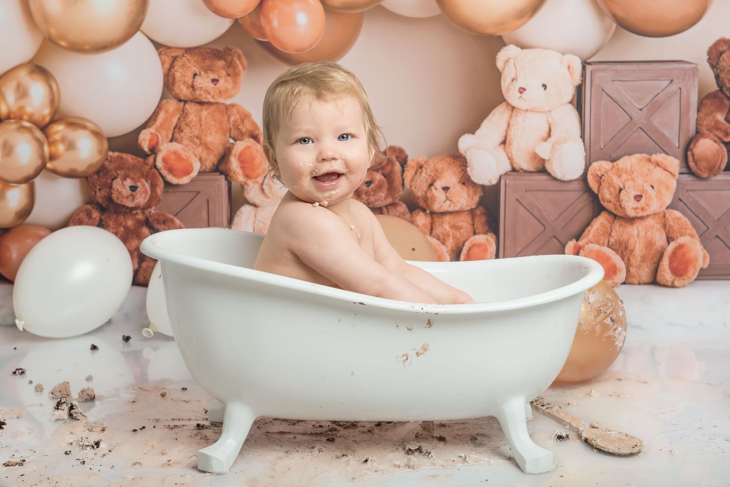 A joyful bath time moment captures the cleanup after a cake smash photo session.