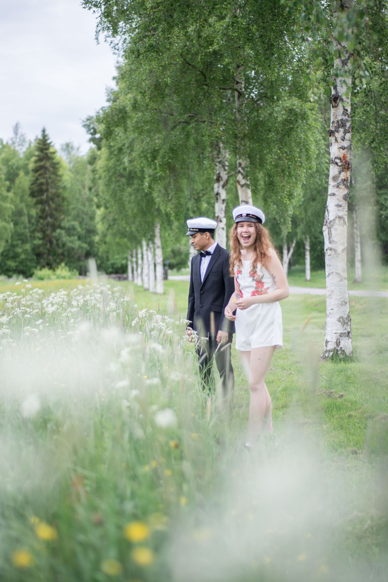 Dreamy outdoor photo session with couple among birch trees and summer wildflowers.
