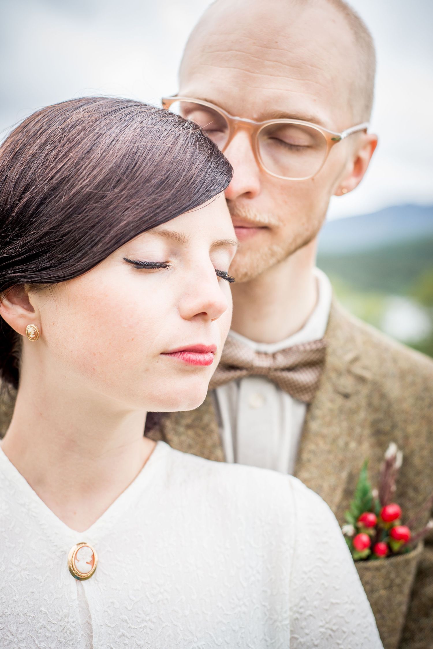Intimate close-up portrait with soft lighting showing vintage eyewear and classic styling.