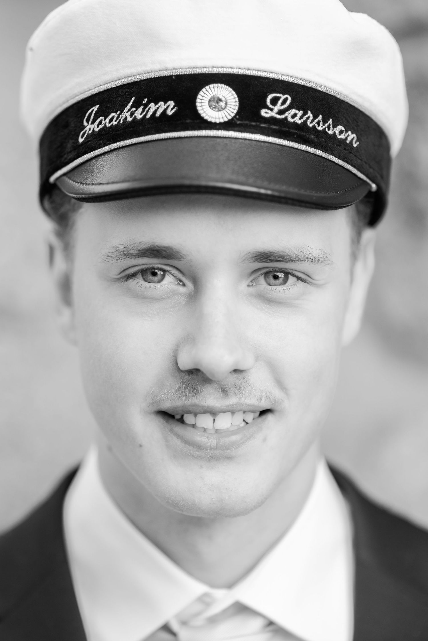 A series of black and white headshots showing different expressions while wearing a sailor cap.