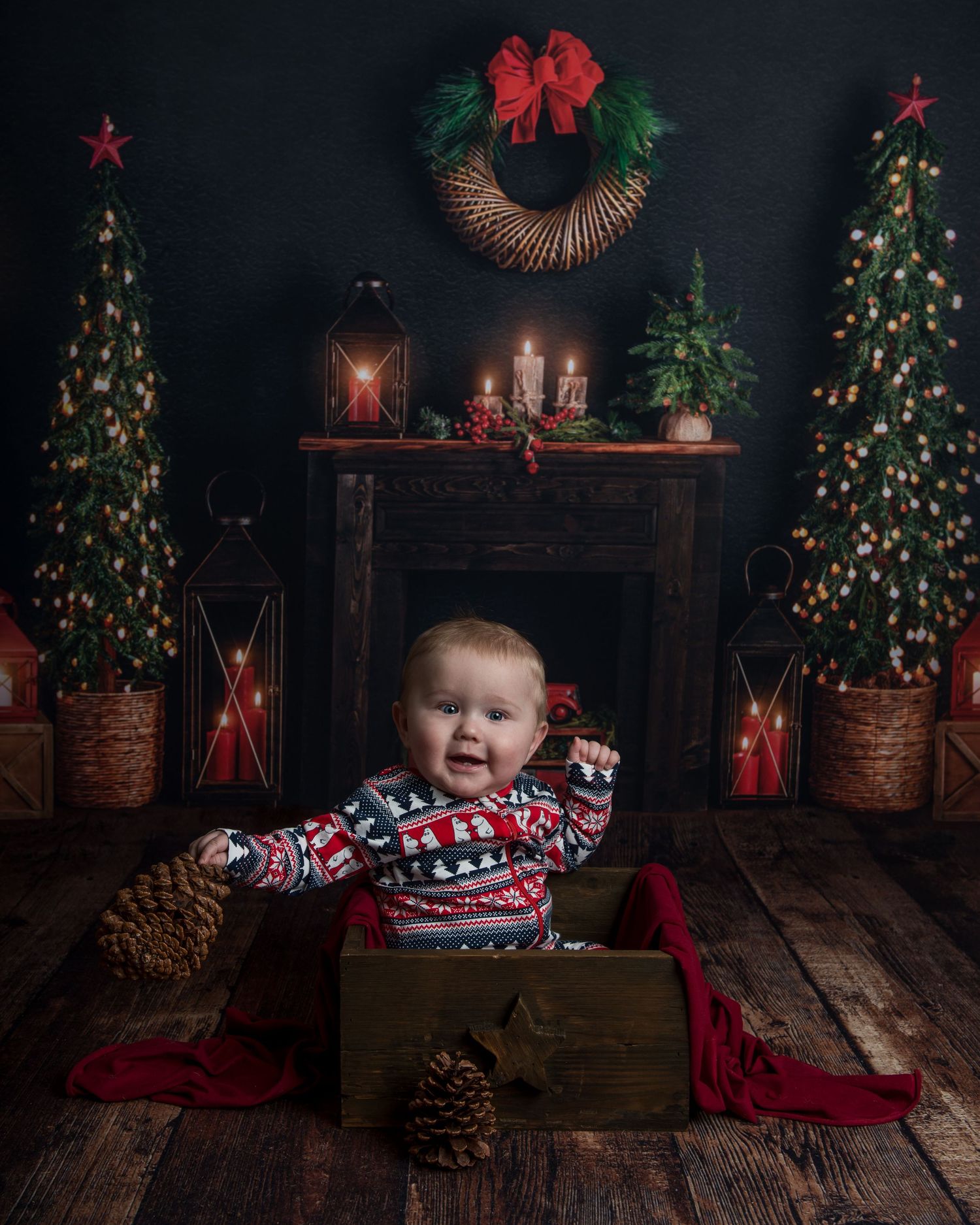 Festive holiday scene with wooden crates, decorated Christmas trees and red accents against dark backdrop.
