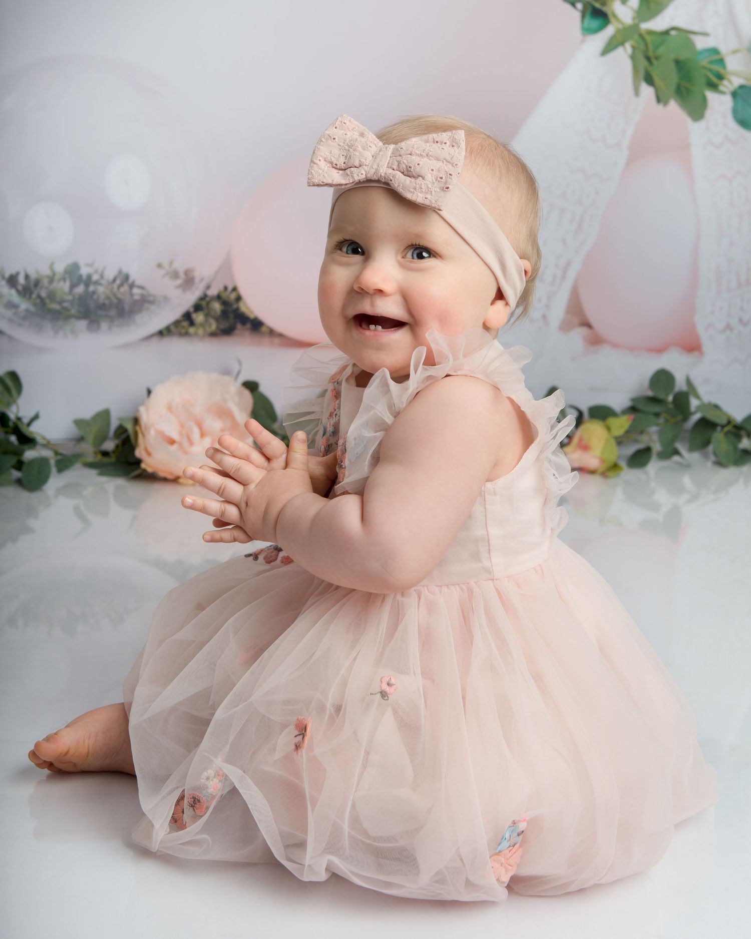 Pink tulle dress birthday photoshoot with floral accents and balloon decorations.