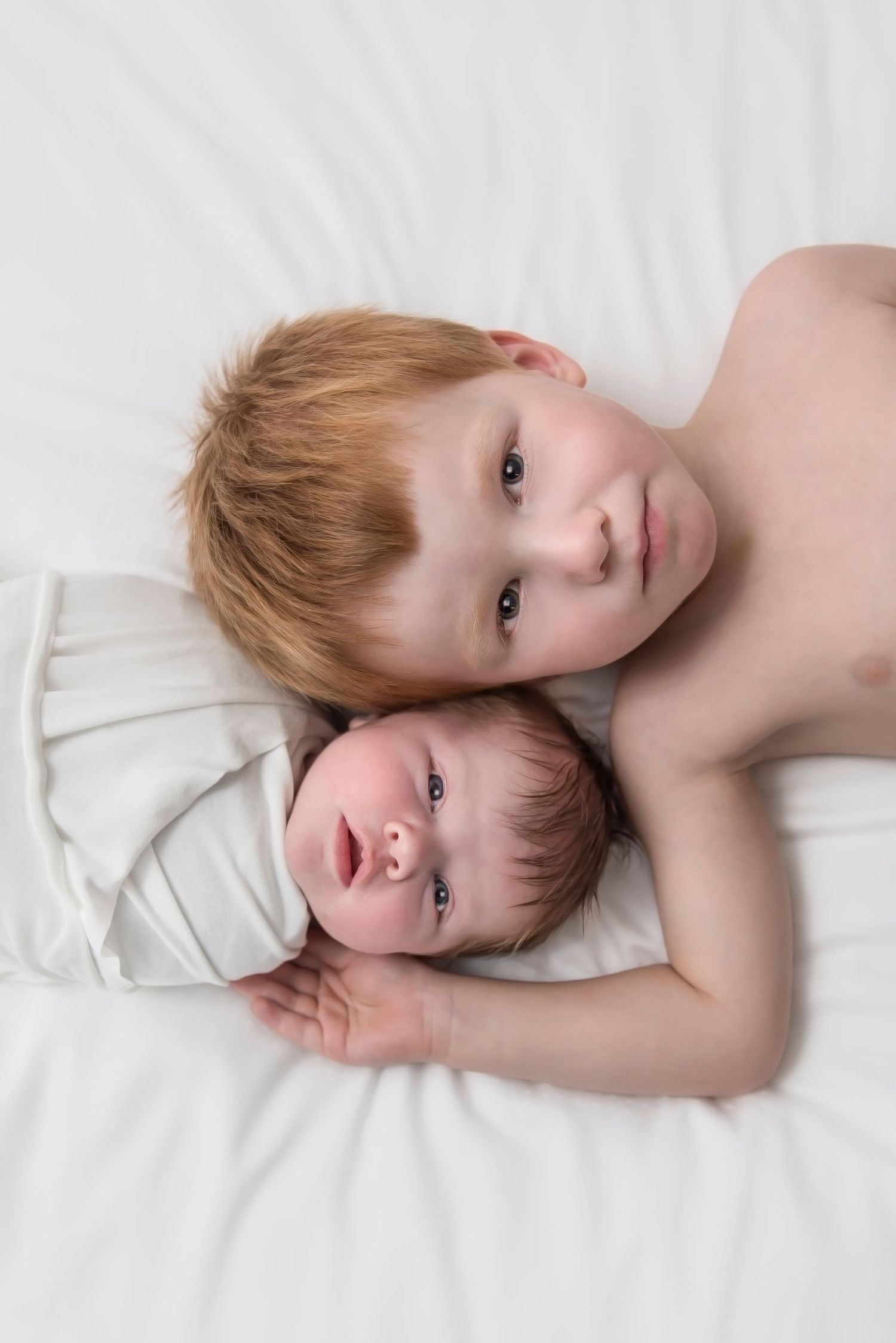 Series of artistic portraits showing child resting on white bedding.