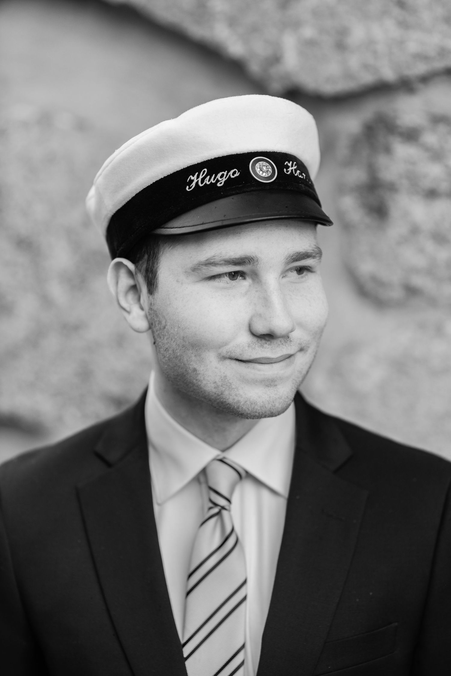 Black and white photos showing different angles of someone in formal attire with a nautical cap.