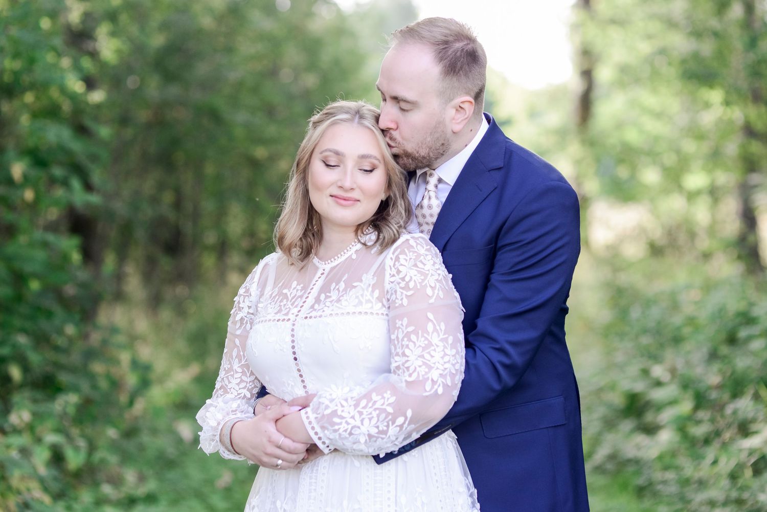 Candid engagement photos of a couple in a lush green outdoor setting.