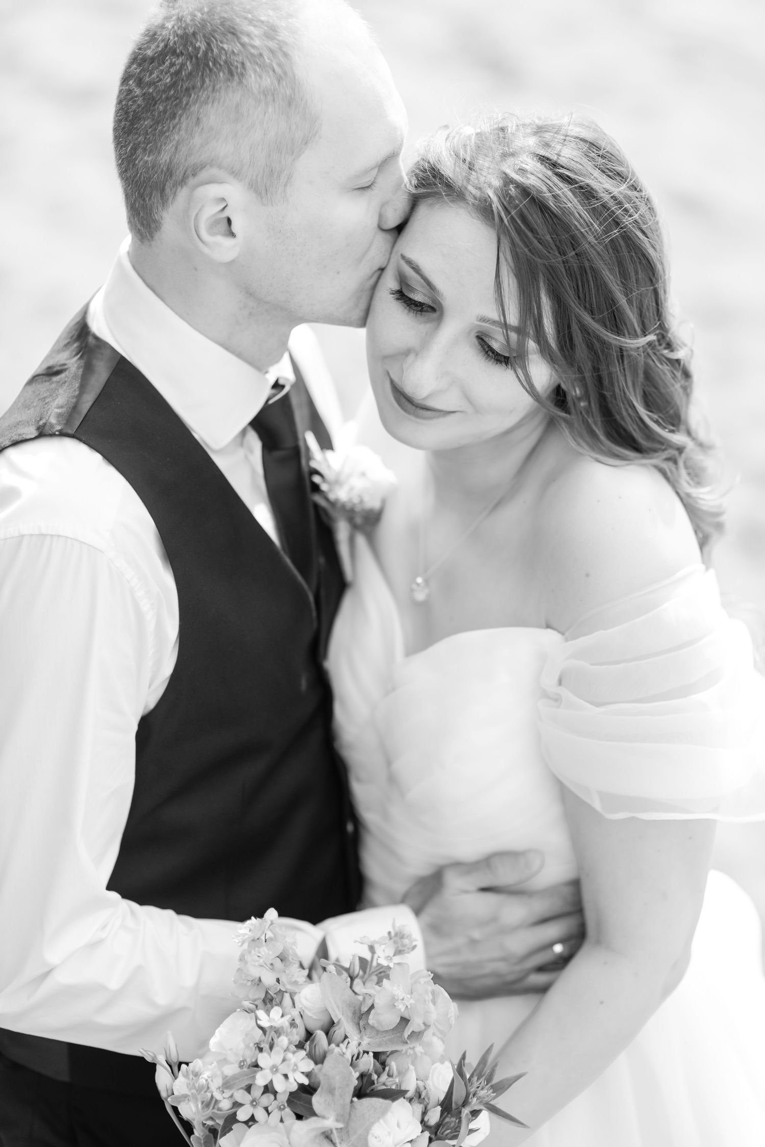 Black and white wedding portraits capturing tender moments between a couple.