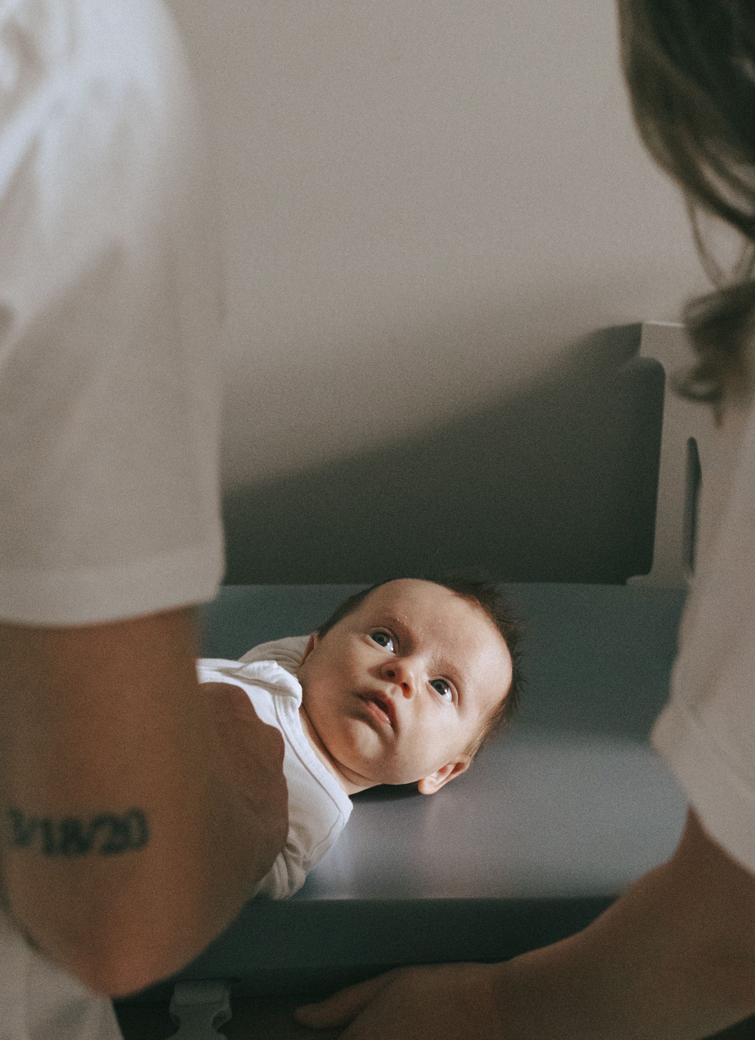 Parents in foreground of image of newborn baby boy.