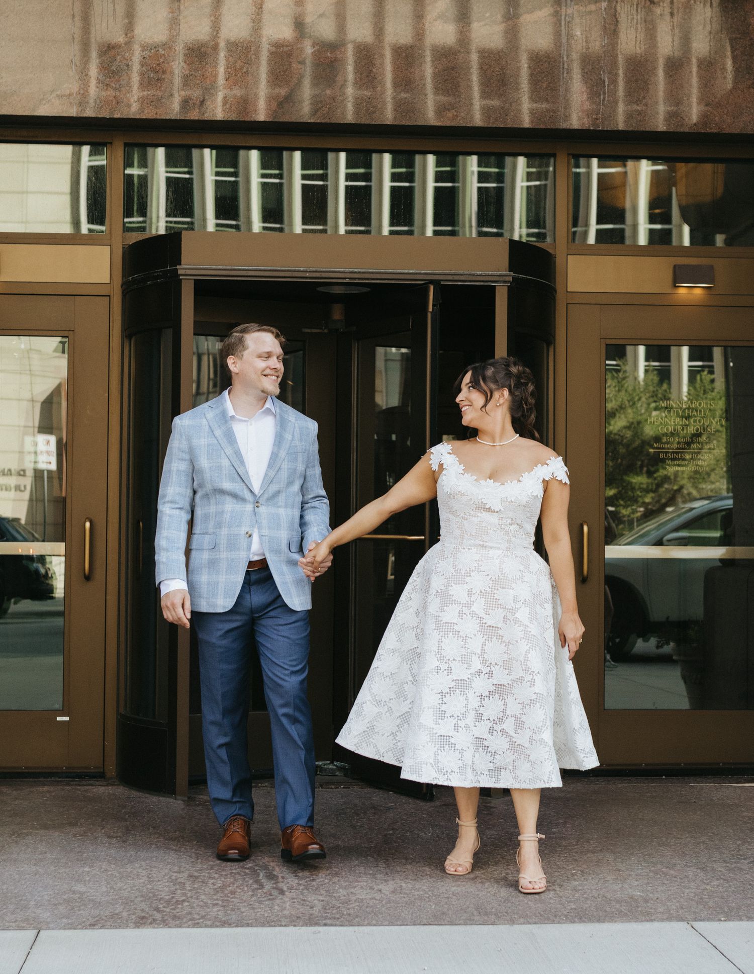 A husband and wife step outside from their courthouse elopement.