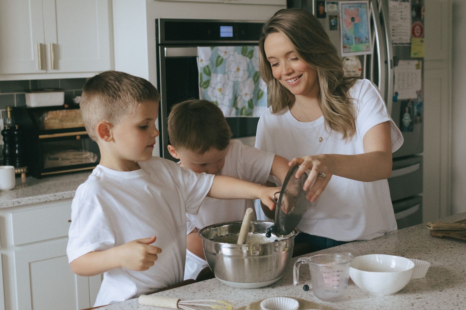 Mother and two sons making blueberry muffins.