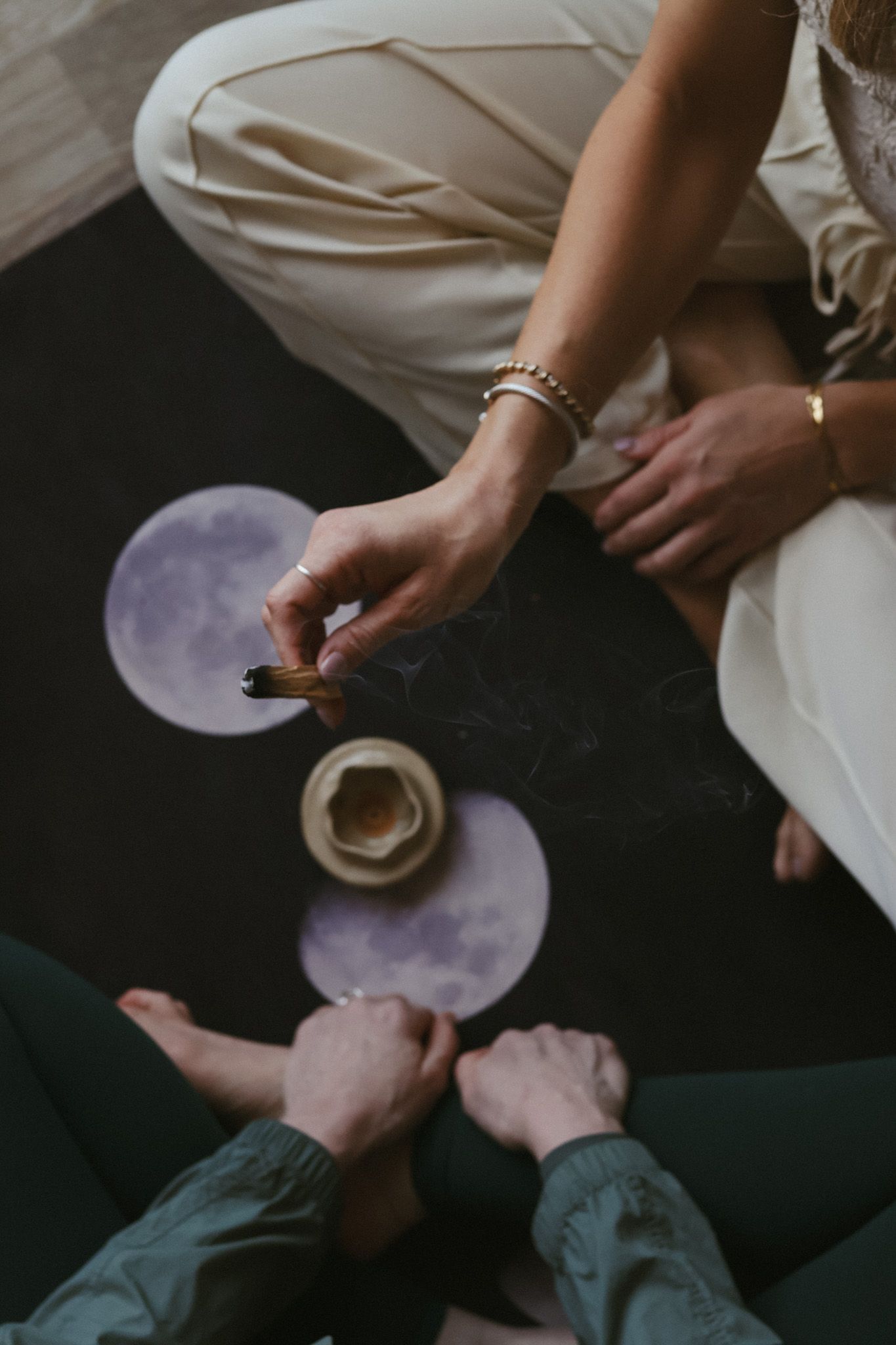 Two hands engaging in spiritual practice of palo Santo smudging.