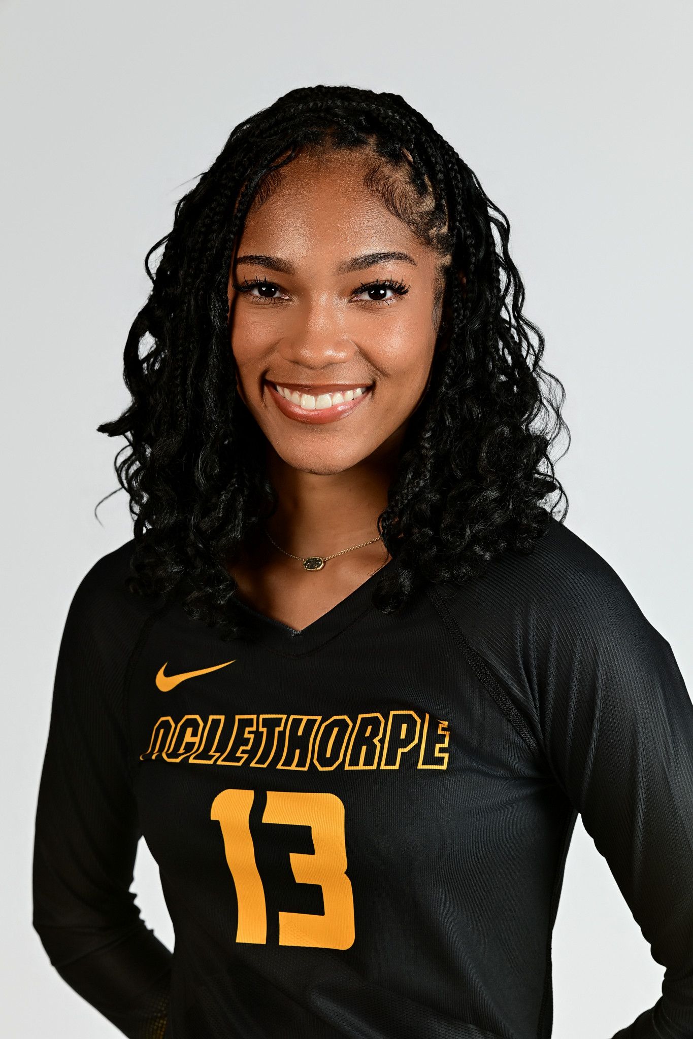 Oglethorpe University volleyball player #13 poses for official team portrait in black Nike jersey.