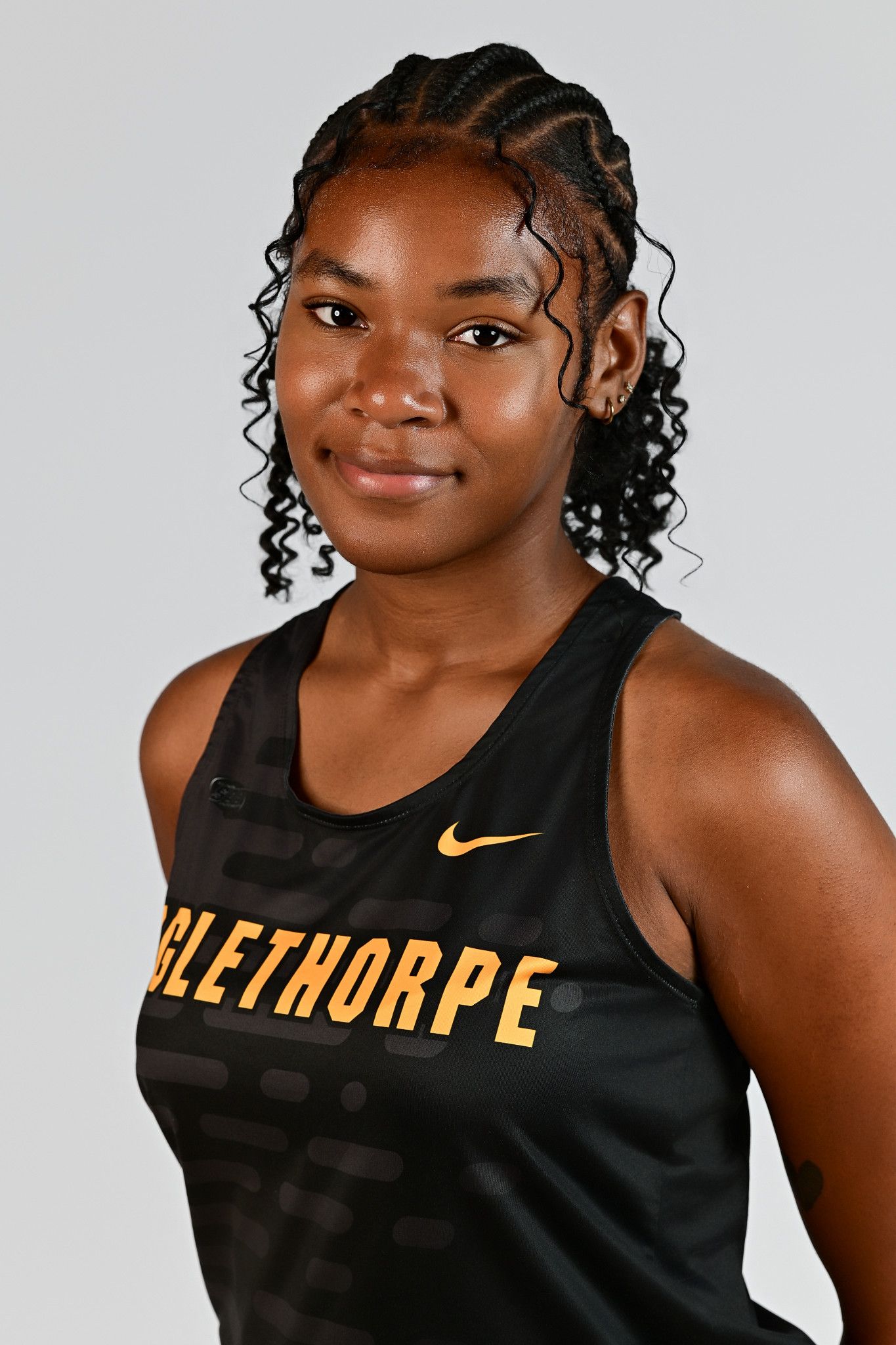 Female Oglethorpe University track and field athlete poses in black Nike uniform for official team portrait photo.