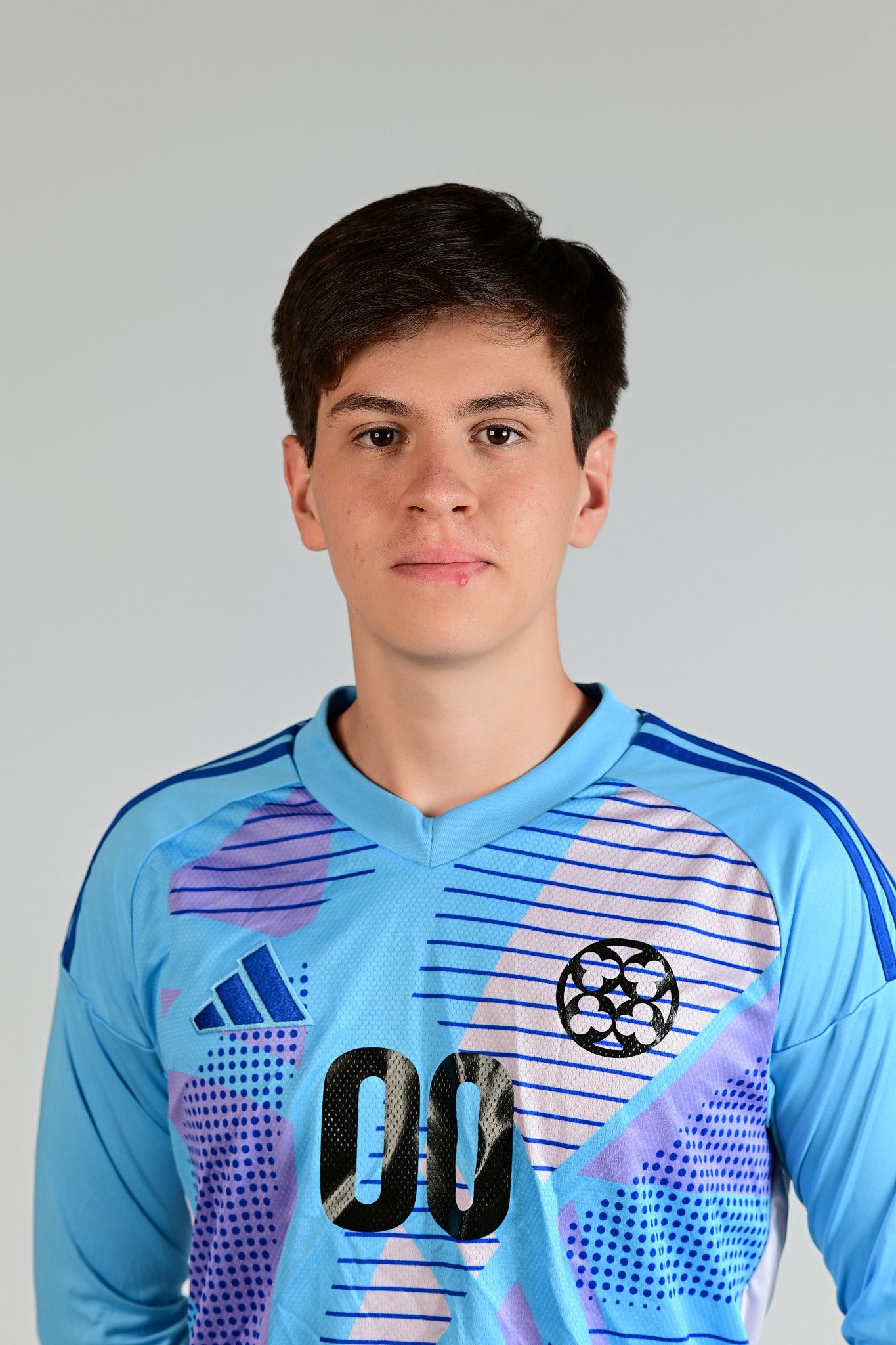 Young male soccer goalkeeper in light blue Adidas jersey numbered 00 poses for official team portrait.