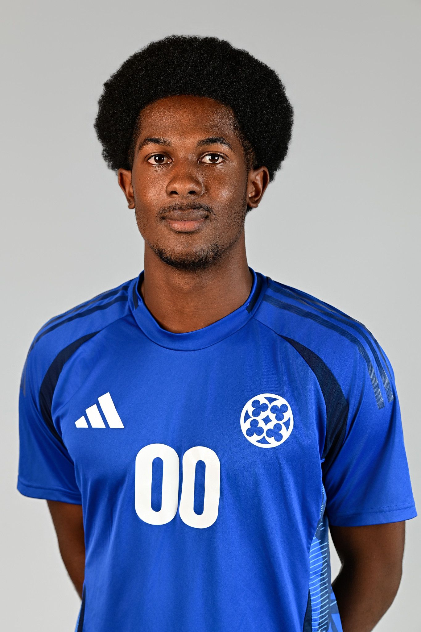 Male soccer player wearing blue Adidas jersey with number 00 poses for official team headshot photo.