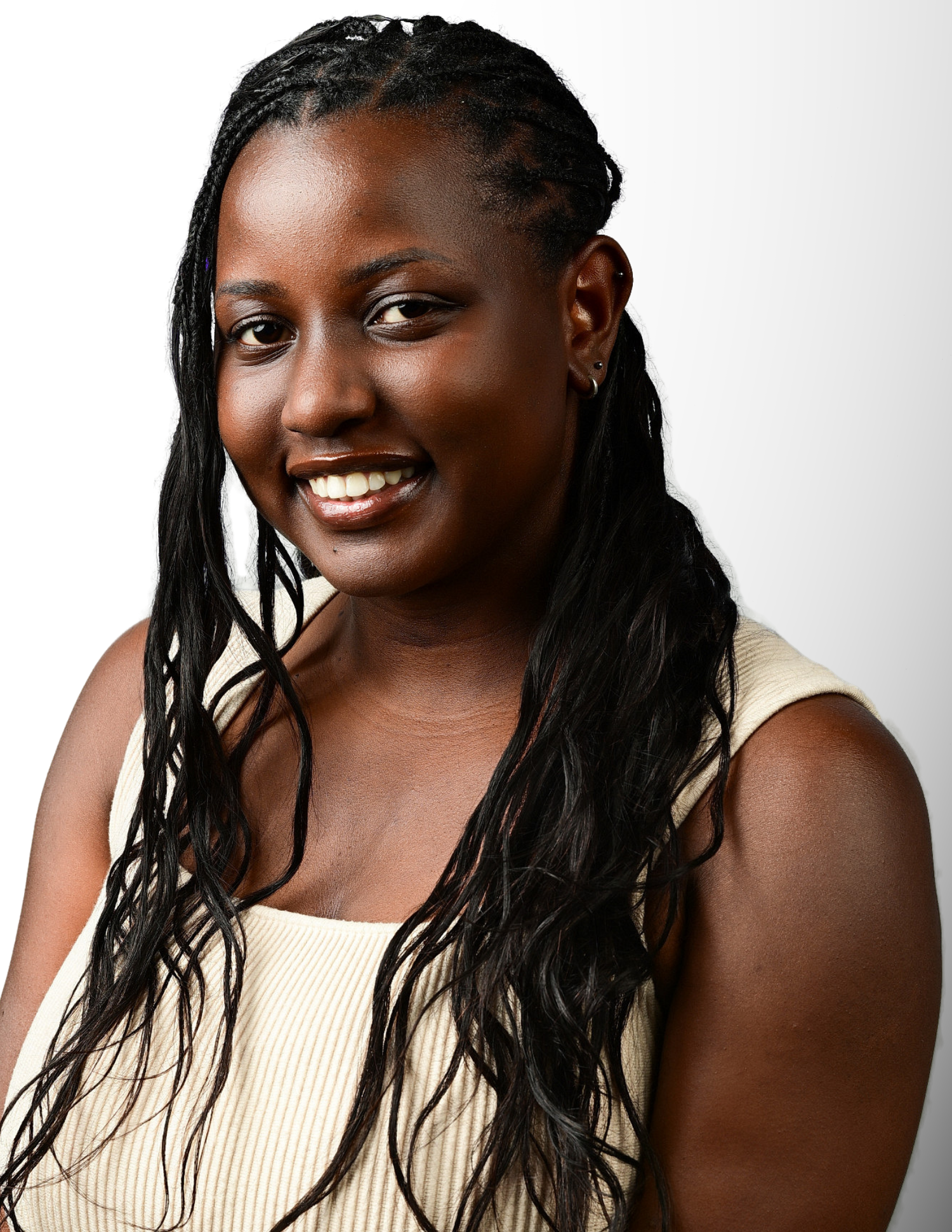 Young woman with long braided hair smiling confidently, wearing a sleeveless cream top against a white background.
