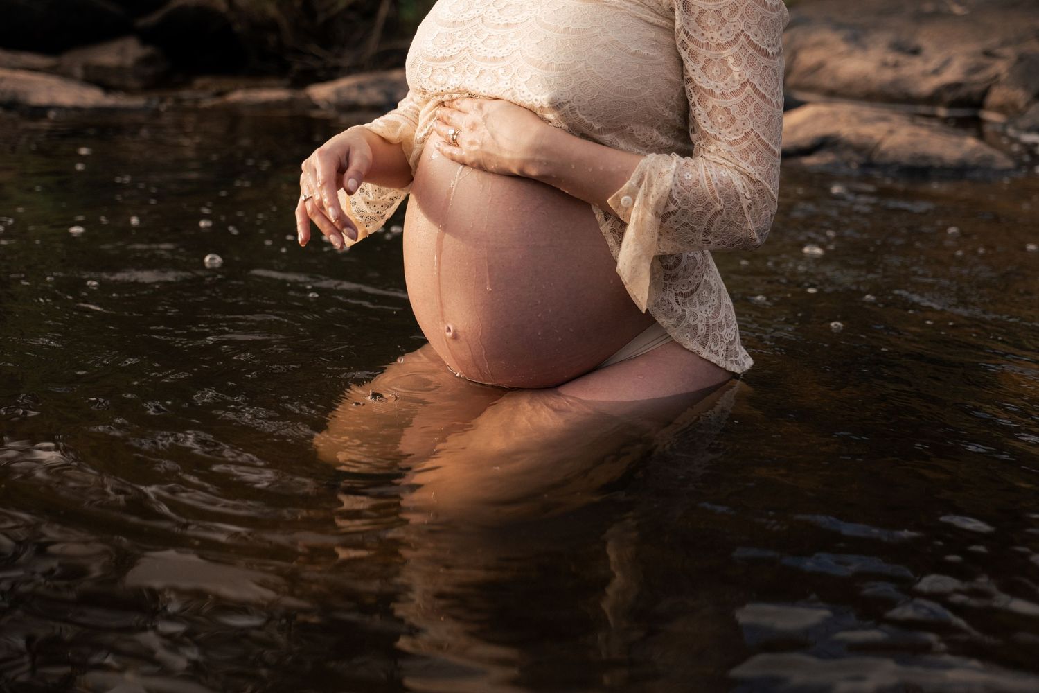 A close up intimate photo of a Perth hills mother celebrating becoming a new mum having photos in the Perth hills waterfalls.