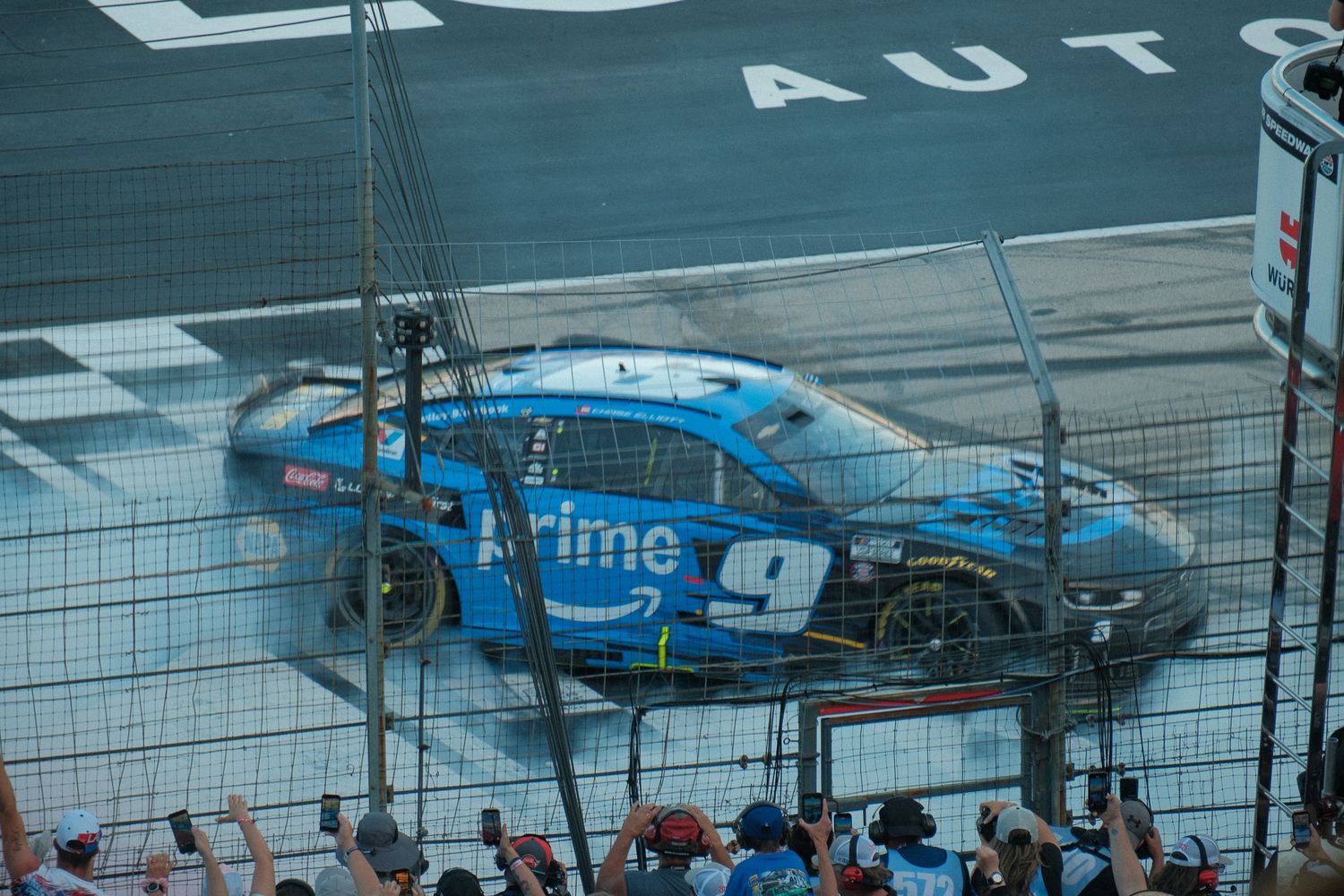 Amazon Prime NASCAR No. 9 blue race car crashes into fence during race event.