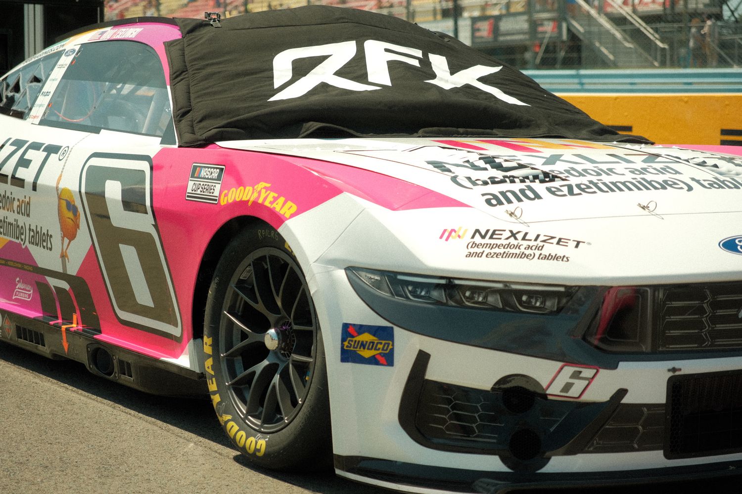 RFK Racing No. 6 NASCAR Cup Series car with pink and white livery on display at a race track.
