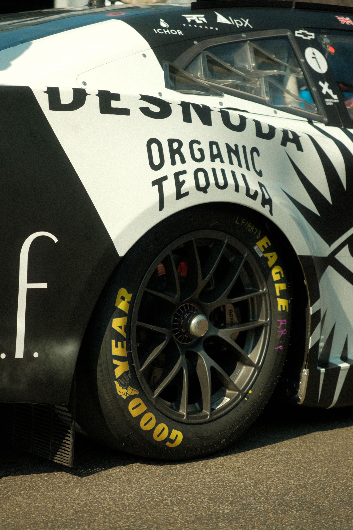 Close-up of Goodyear Eagle tire on Desnuda Organic Tequila sponsored NASCAR race car.
