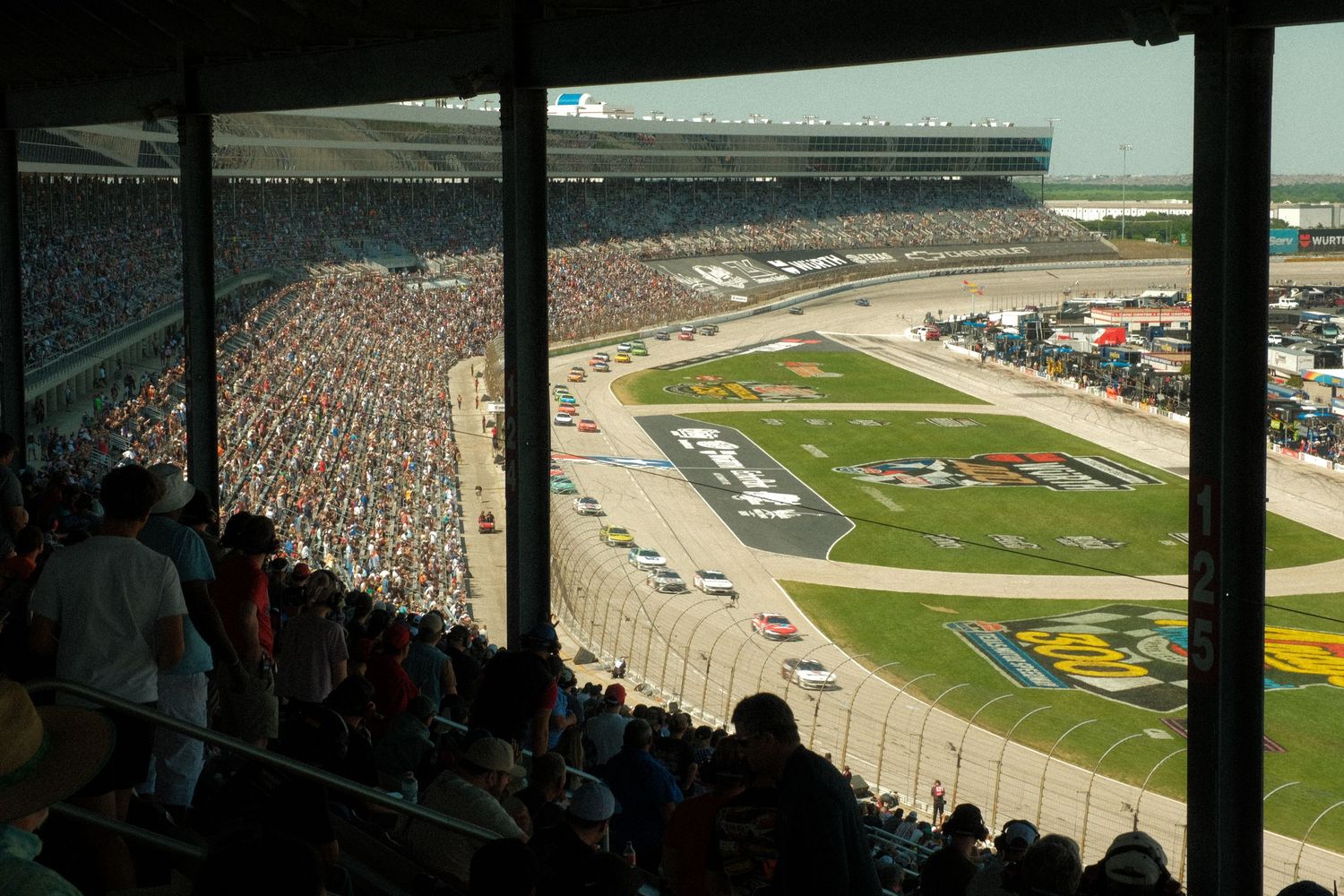 Aerial view of a packed NASCAR race at Texas Motor Speedway with cars on the oval track.