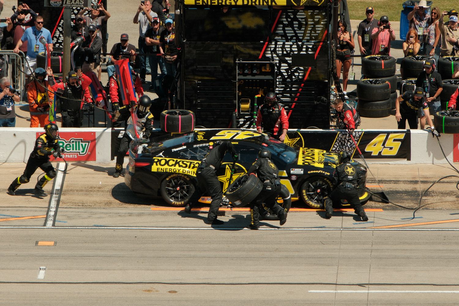 NASCAR pit crew servicing #45 Rockstar Energy car during race stop.
