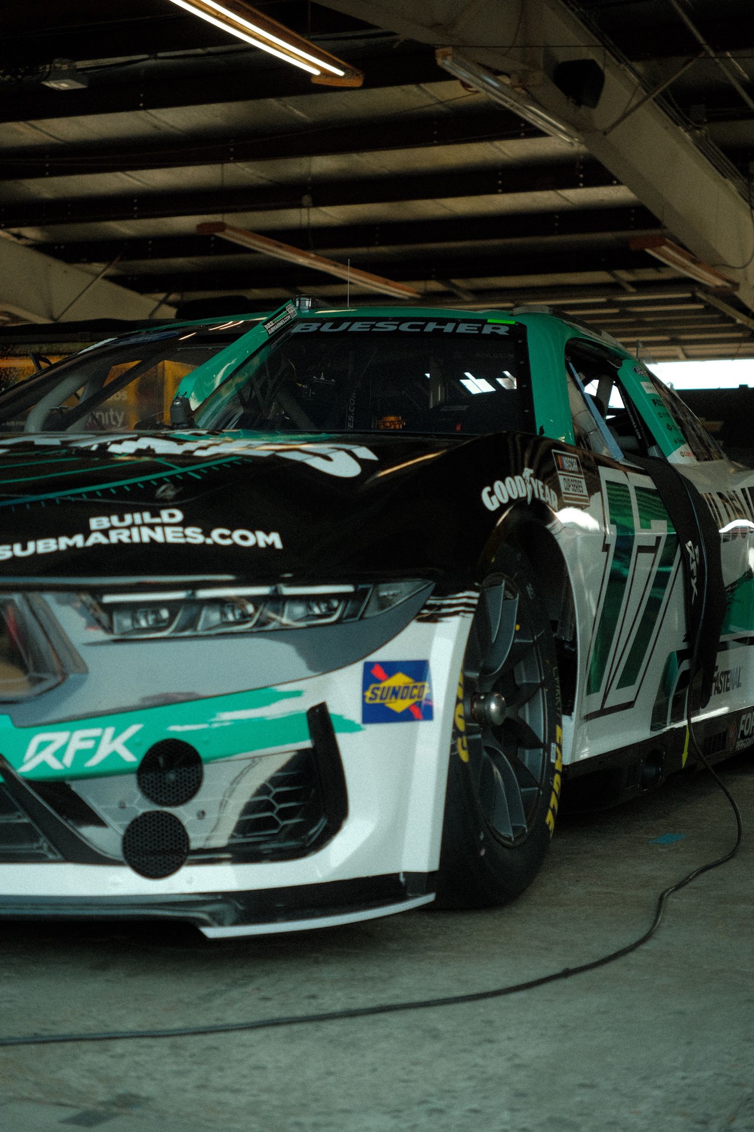 RFK Racing No. 17 Buescher BuildSubmarines.com black and green NASCAR stock car in garage.
