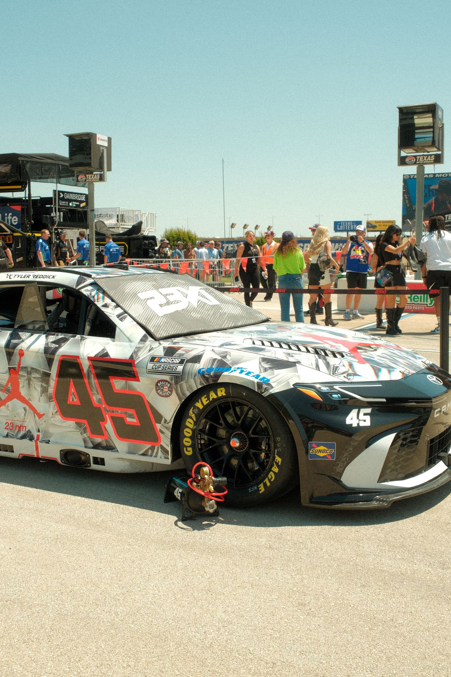 NASCAR number 45 Jordan Brand sponsored race car displayed at a sunny outdoor racing event with spectators.
