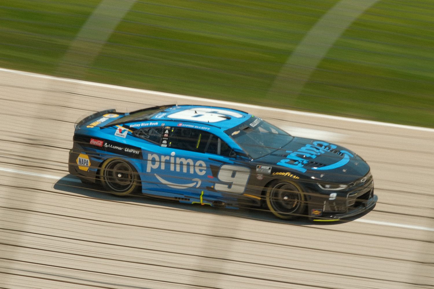 NASCAR race car #9 with Amazon Prime sponsorship speeding on track, black and blue livery.