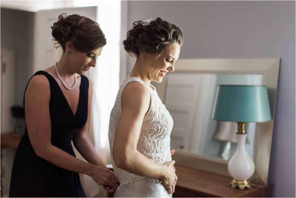 Intimate moment during wedding preparations in a sunlit room with elegant decor.