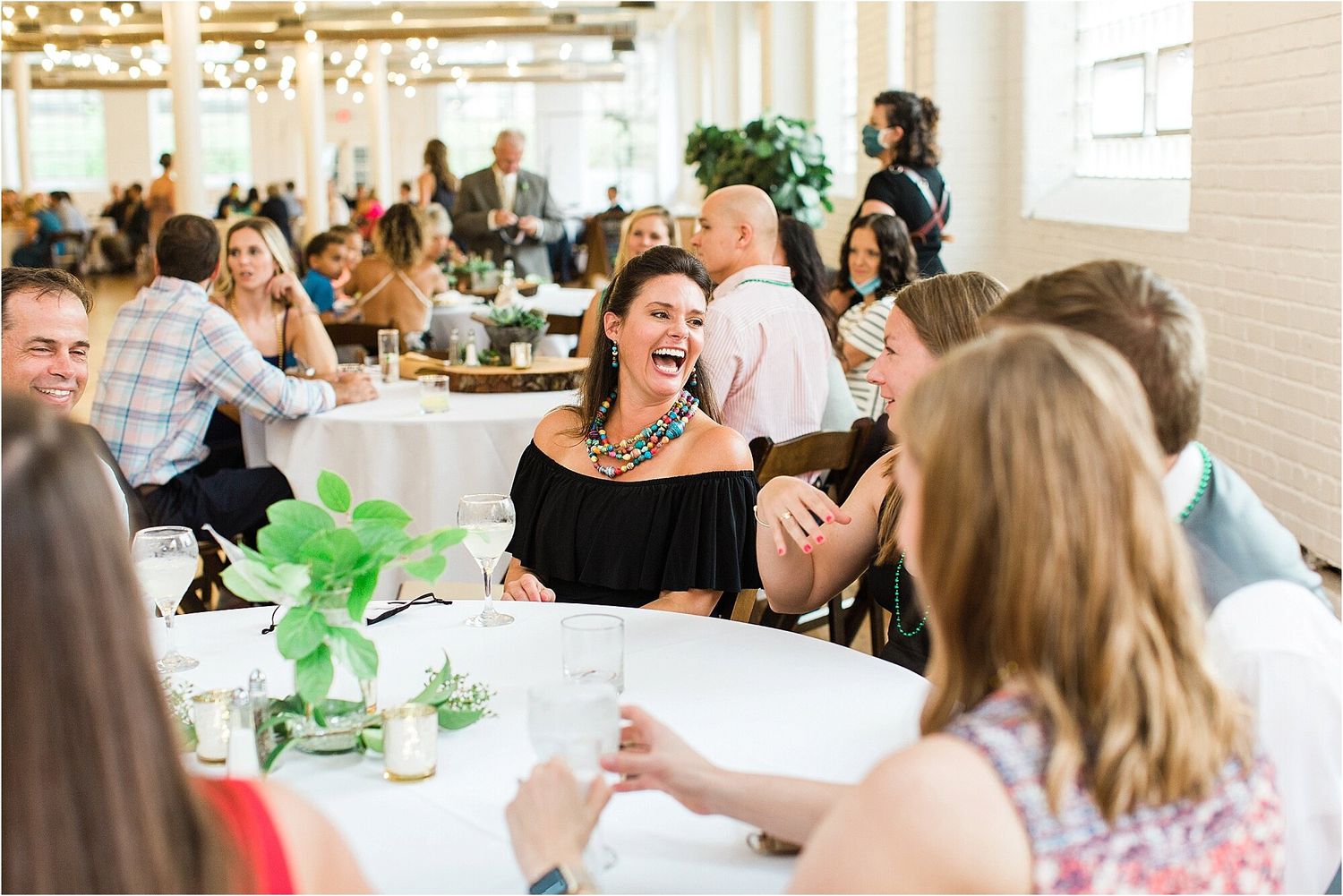 Wedding guests enjoying a lively reception with green table decorations.