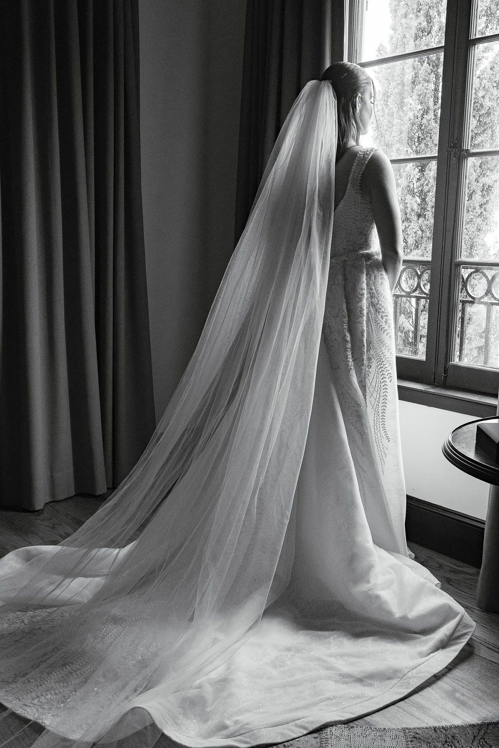 Bride looks out the window at the rain on her Hotel Domestique wedding day