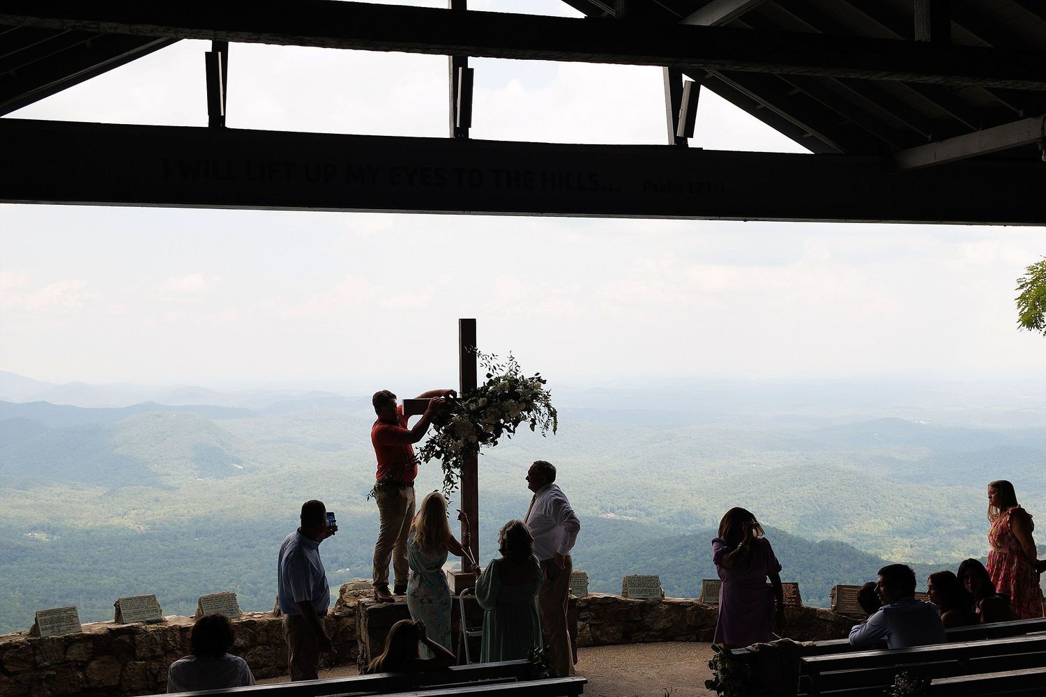 Silhouette of wedding ceremony at mountain overlook with scenic vista.