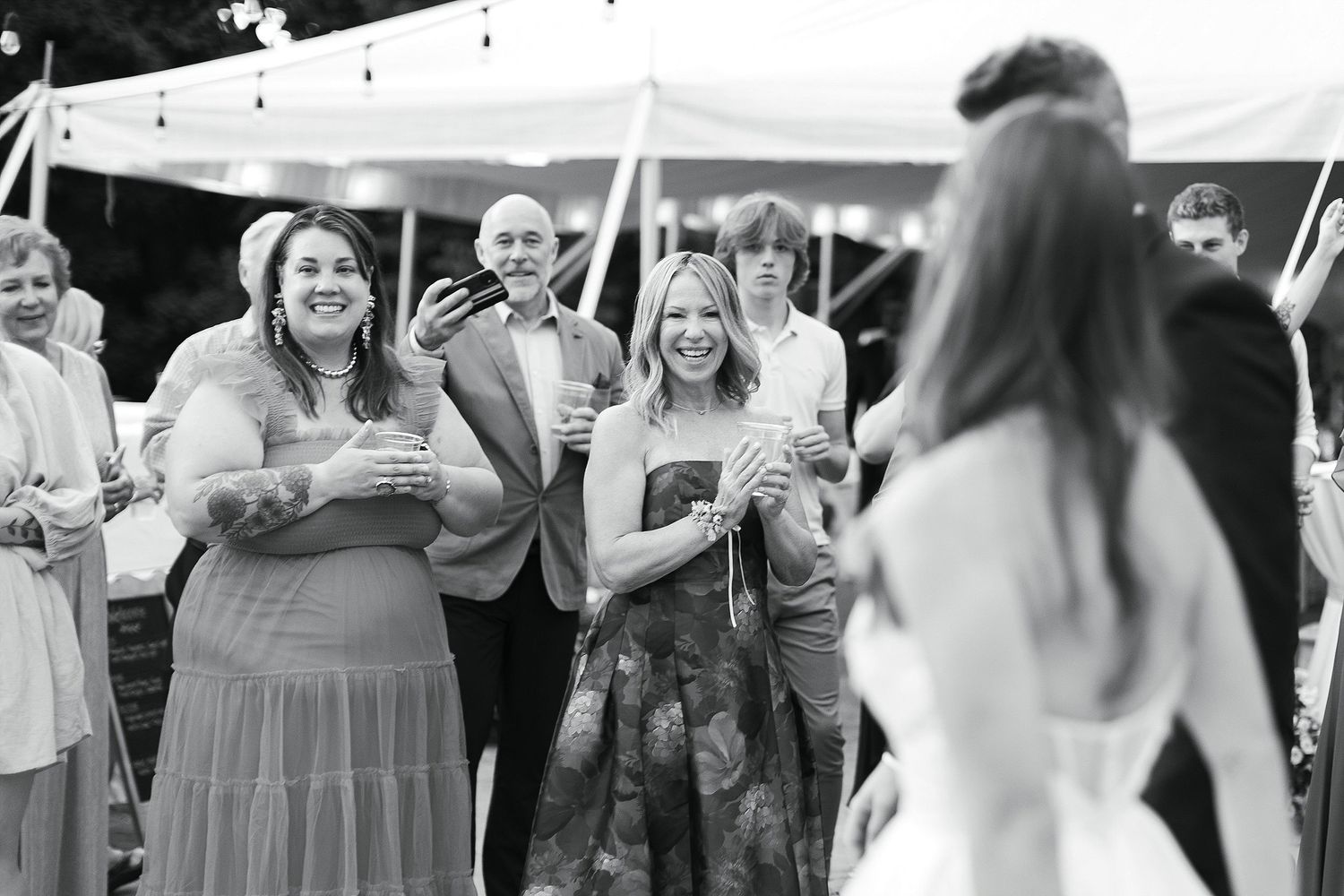 Guests enjoying outdoor wedding reception under string lights.