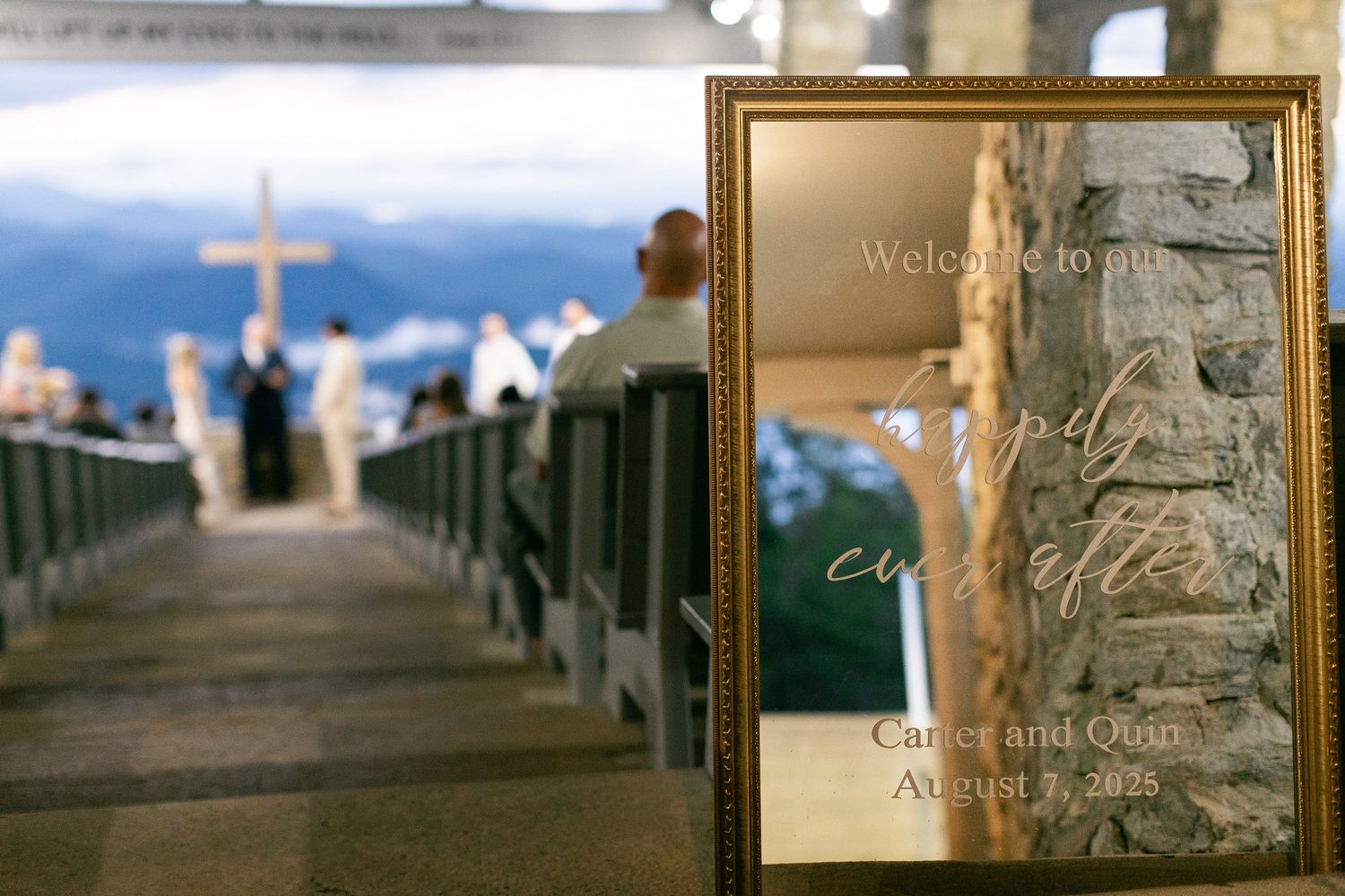 An elegant wedding ceremony setup at a beach pier with a framed program in the foreground and ocean view backdrop.