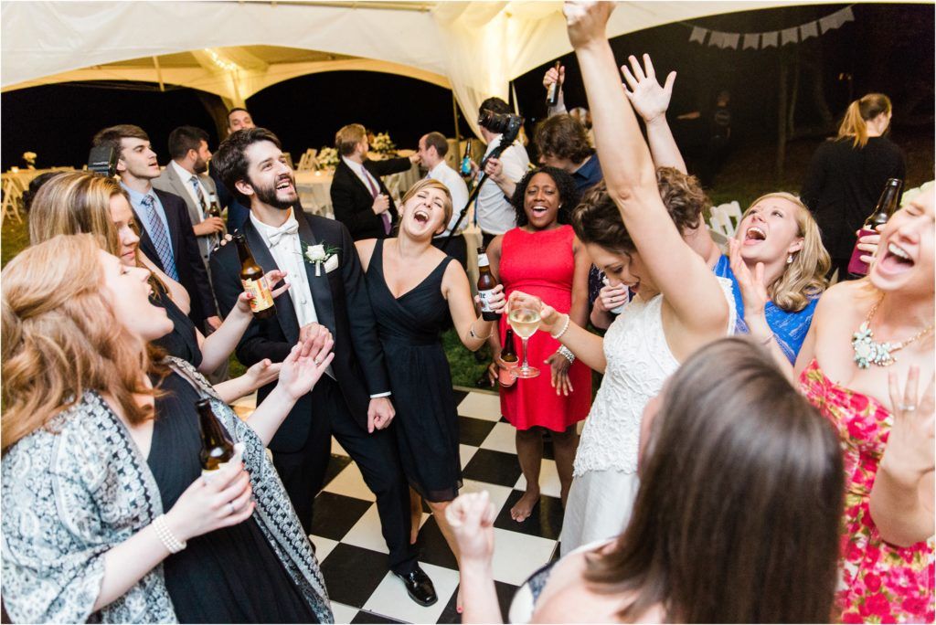 Energetic wedding reception dance floor filled with celebrating guests.