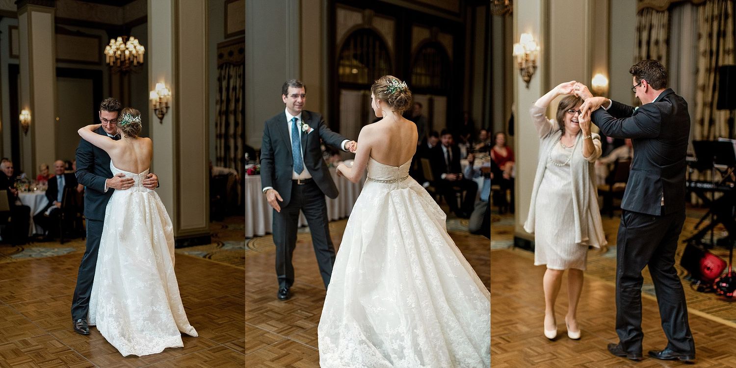 Wedding guests dancing together in an elegant ballroom with chandeliers.